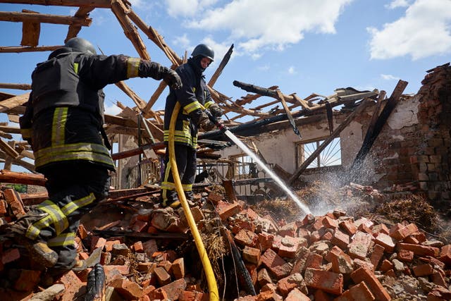 Ukrainian rescuers work at a site of a rocket hit to the riding hall of the Equestrian Center of the Veterinary Academy in Mala Danylivka village near Kharkiv, Ukraine, on May 30