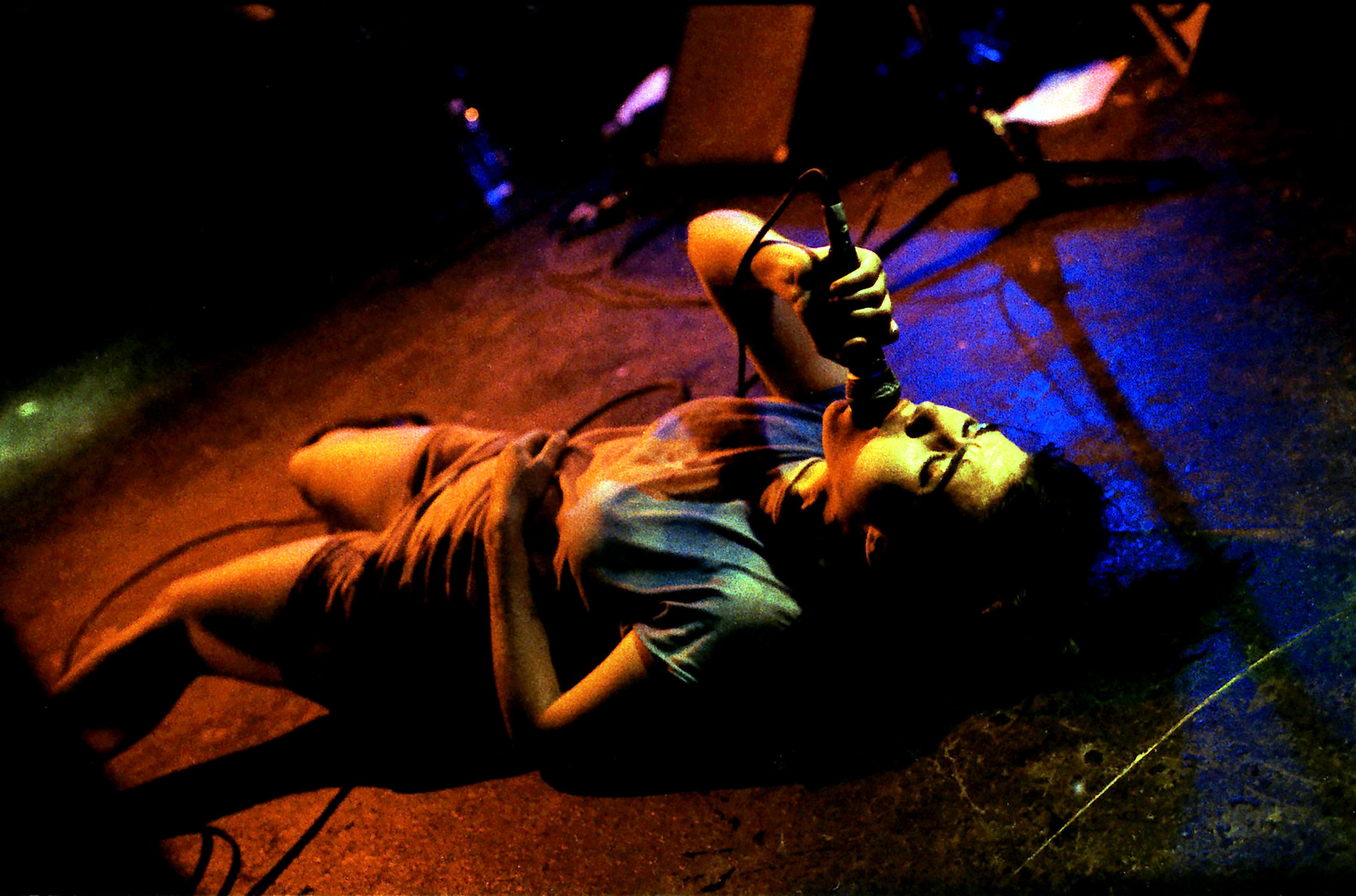 Hanna deita-se de costas enquanto se apresenta em Bikini Kill em Hollywood em novembro de 1994