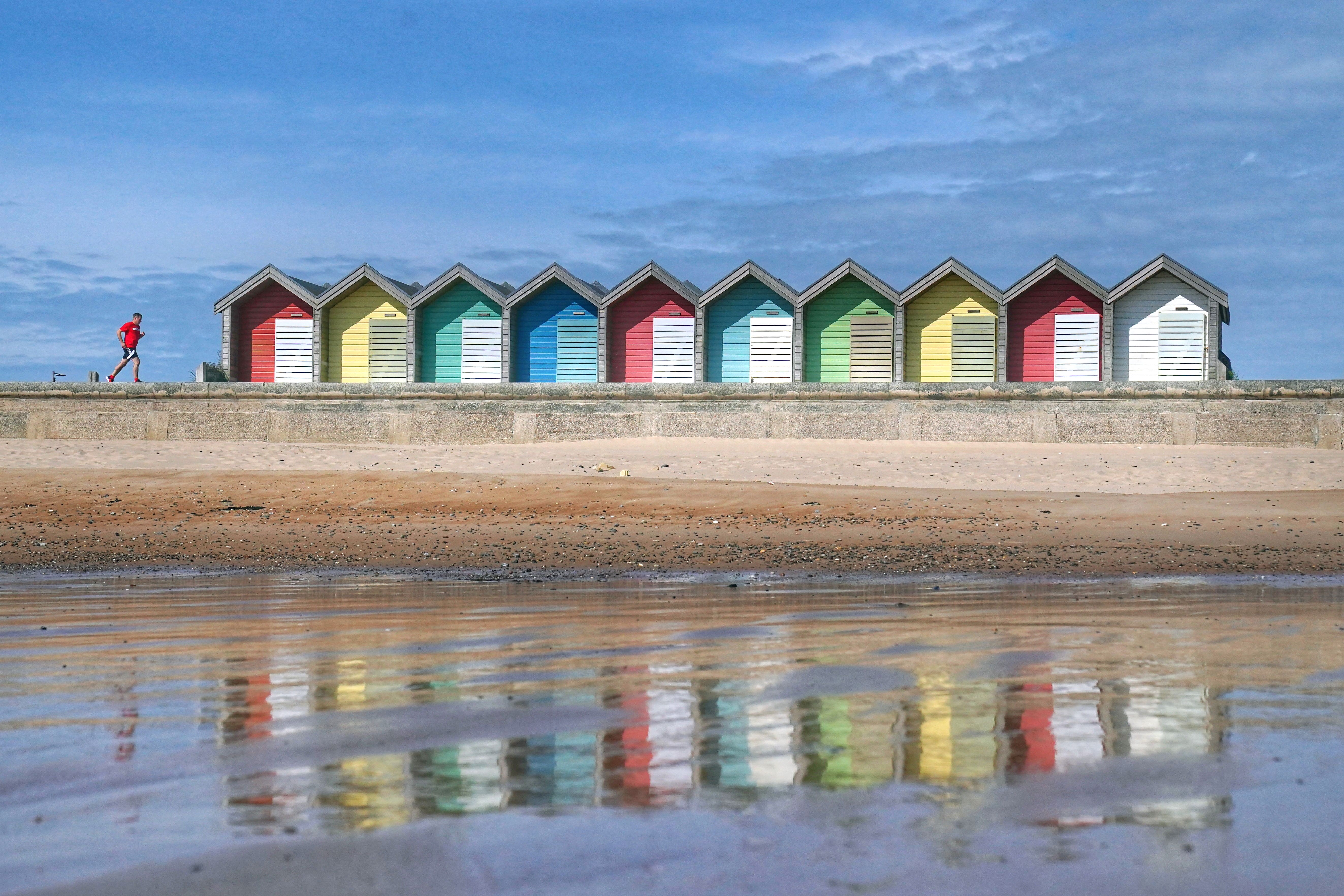 A runner out in the sunshine at Blyth beach in Northumberland (PA)