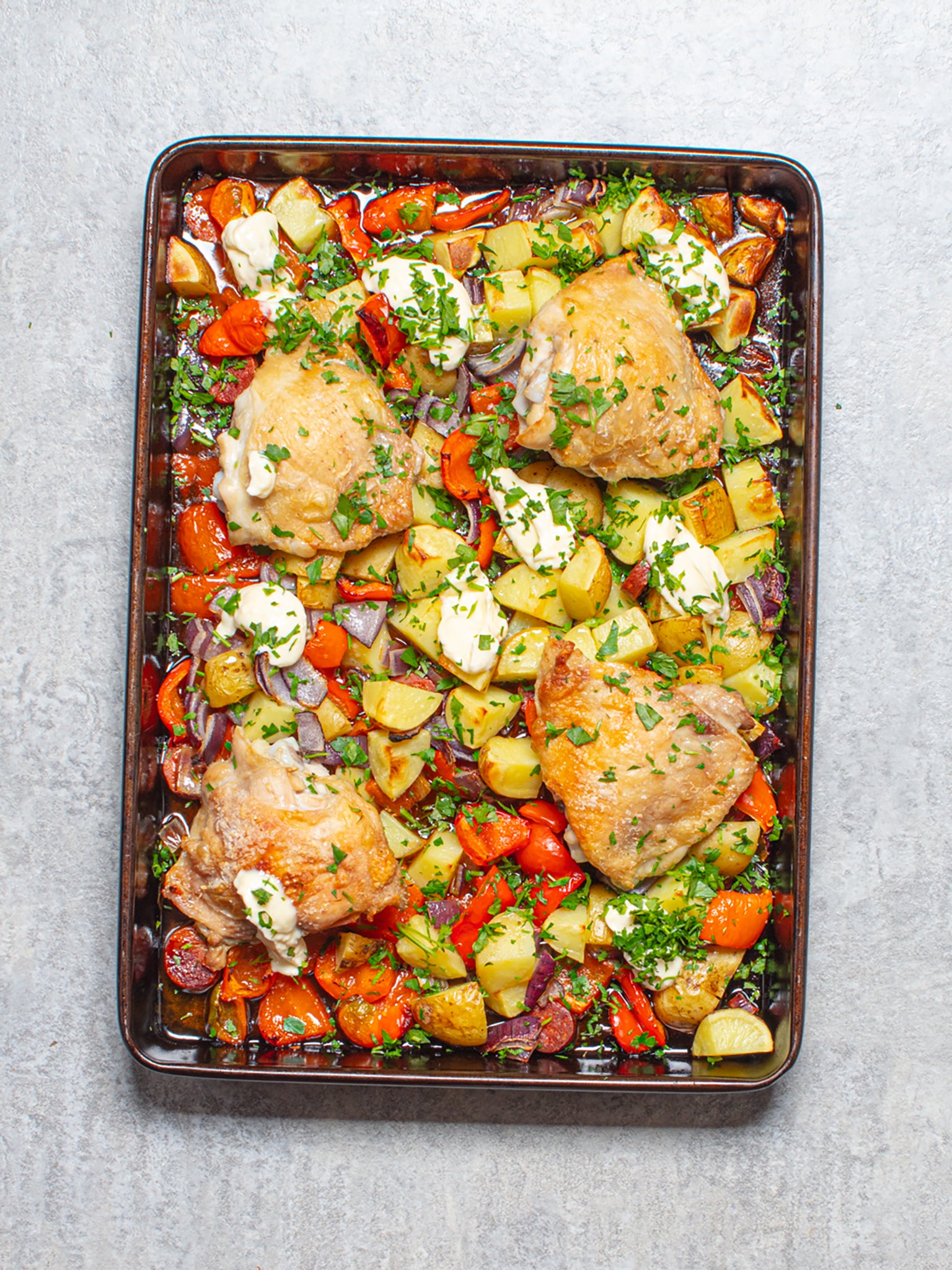 A vibrant and hearty traybake featuring chicken, chorizo and red peppers, served with a creamy garlic aioli