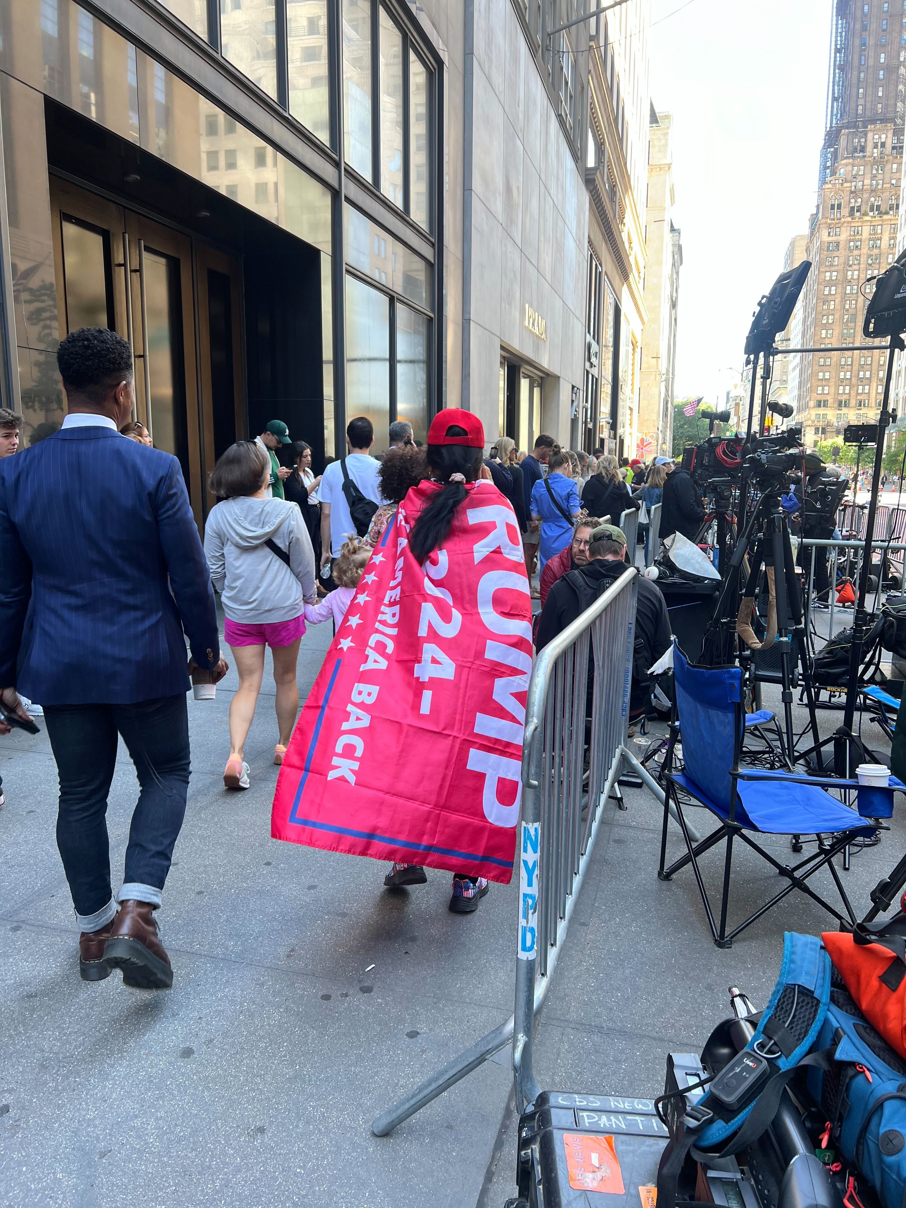 A Trump supporter wears a flag backing the former president ahead of his Trump Tower press conference