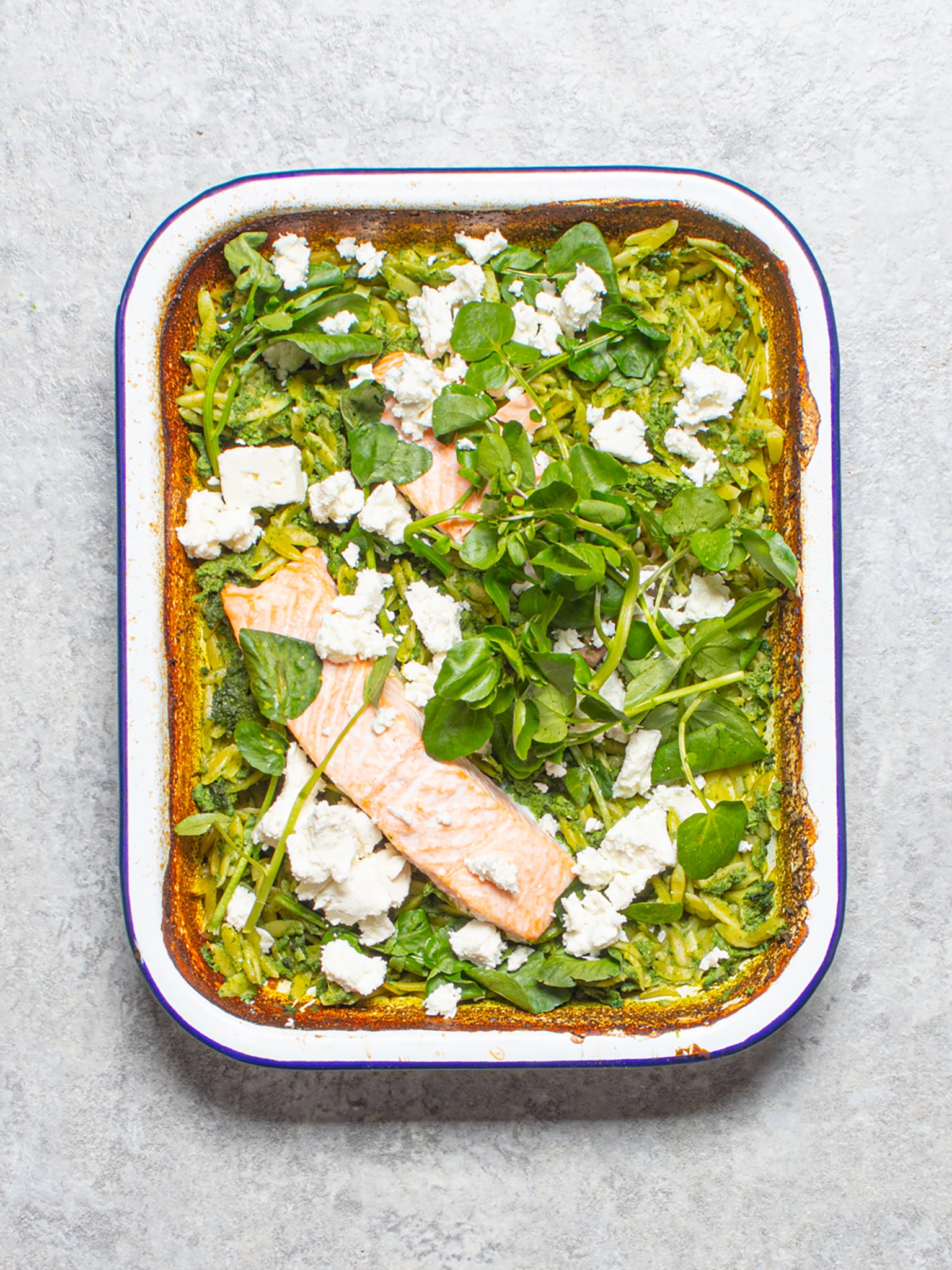 A fresh and flavourful traybake with tender salmon, watercress and creamy orzo, topped with crumbled feta