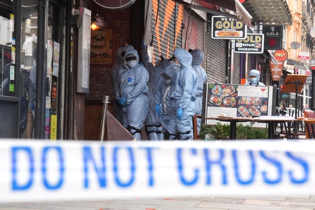 <p>Police forensic officers at the scene of the shooting at Kingsland High Street in Dalston, east London</p>