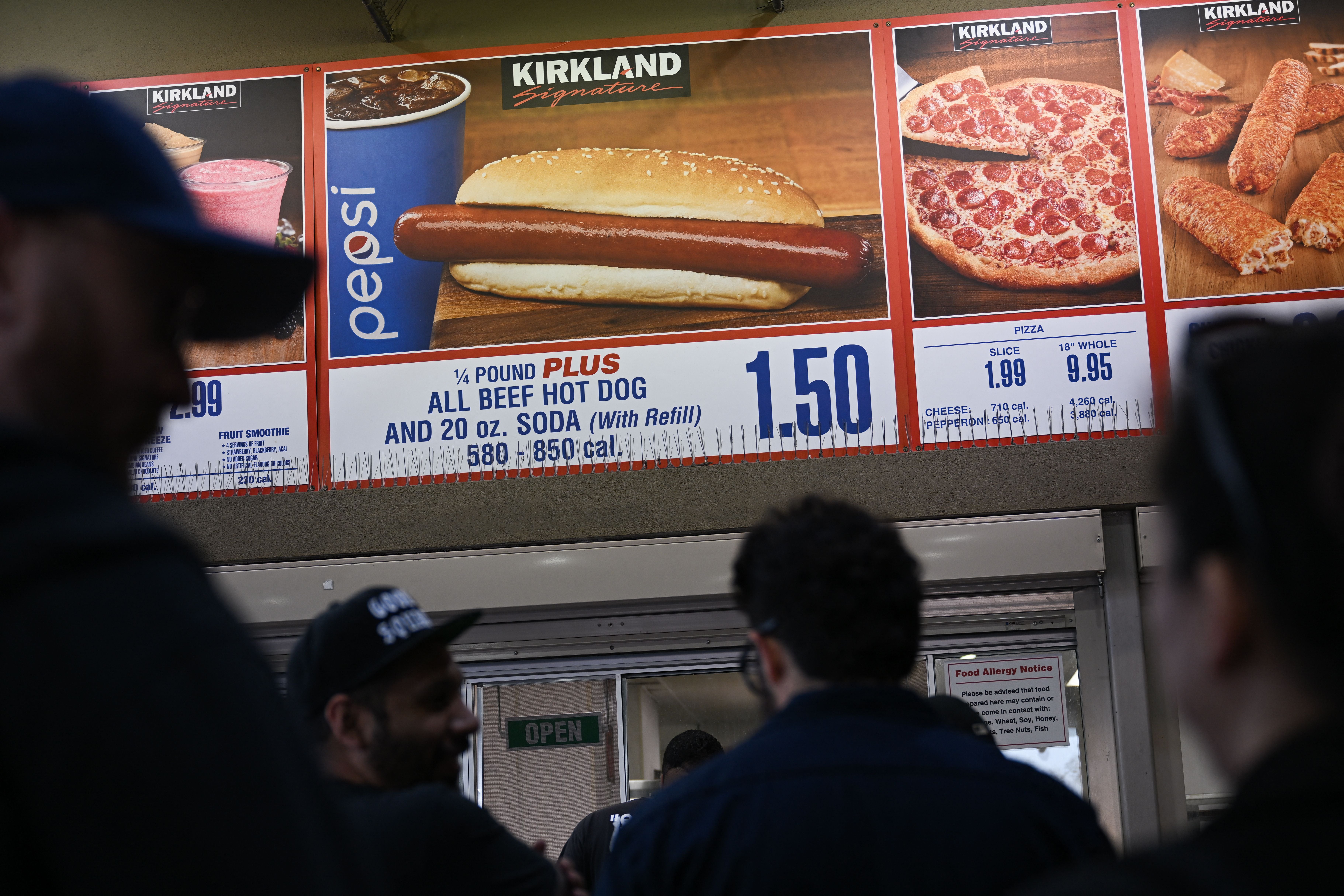 Customers wait in line to order below signage for the Costco Kirkland Signature $1.50 hot dog and soda combo, which has maintained the same price since 1985. The company’s new Chief Financial Officer, Gary Millerchip, said he does not intend to change the price