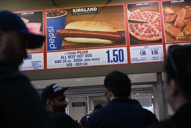 <p>Customers wait in line to order below signage for the Costco Kirkland Signature $1.50 hot dog and soda combo, which has maintained the same price since 1985. The company’s new Chief Financial Officer, Gary Millerchip, said he does not intend to change the price</p>