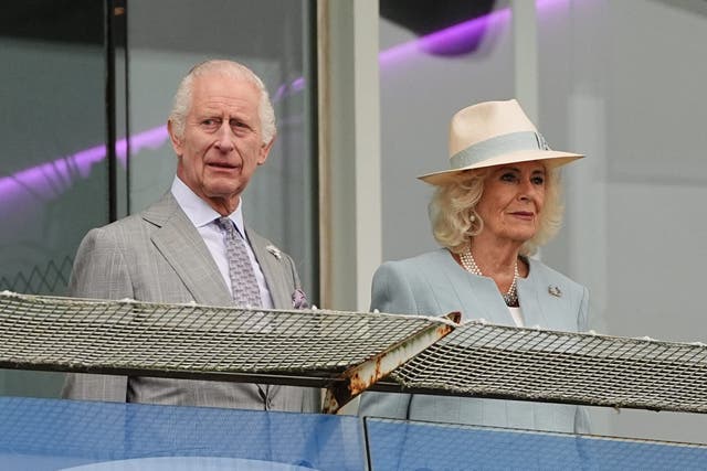 The King and Queen ahead of their horse Treasure racing in The Oaks (PA)