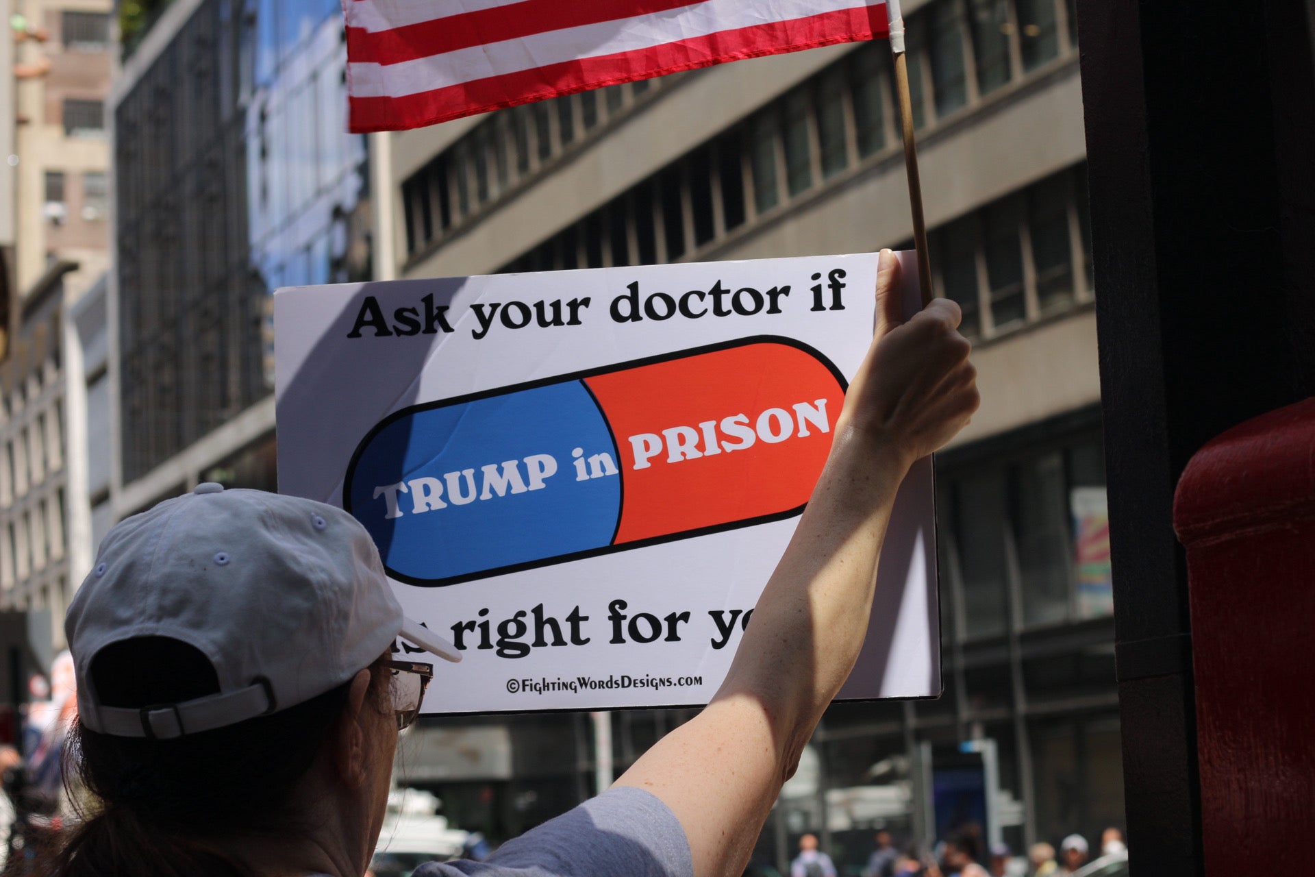 A Trump protestor holds a sign saying, “Ask your doctor if Trump in prison is right for you” outside of Trump Tower on 31 May