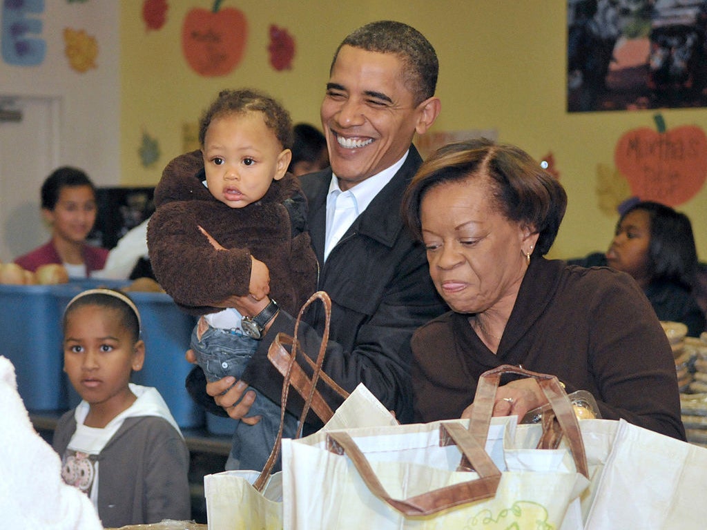 Marian Robinson and Barack Obama hand out food at a charity giveaway in November 2009, Washington DC