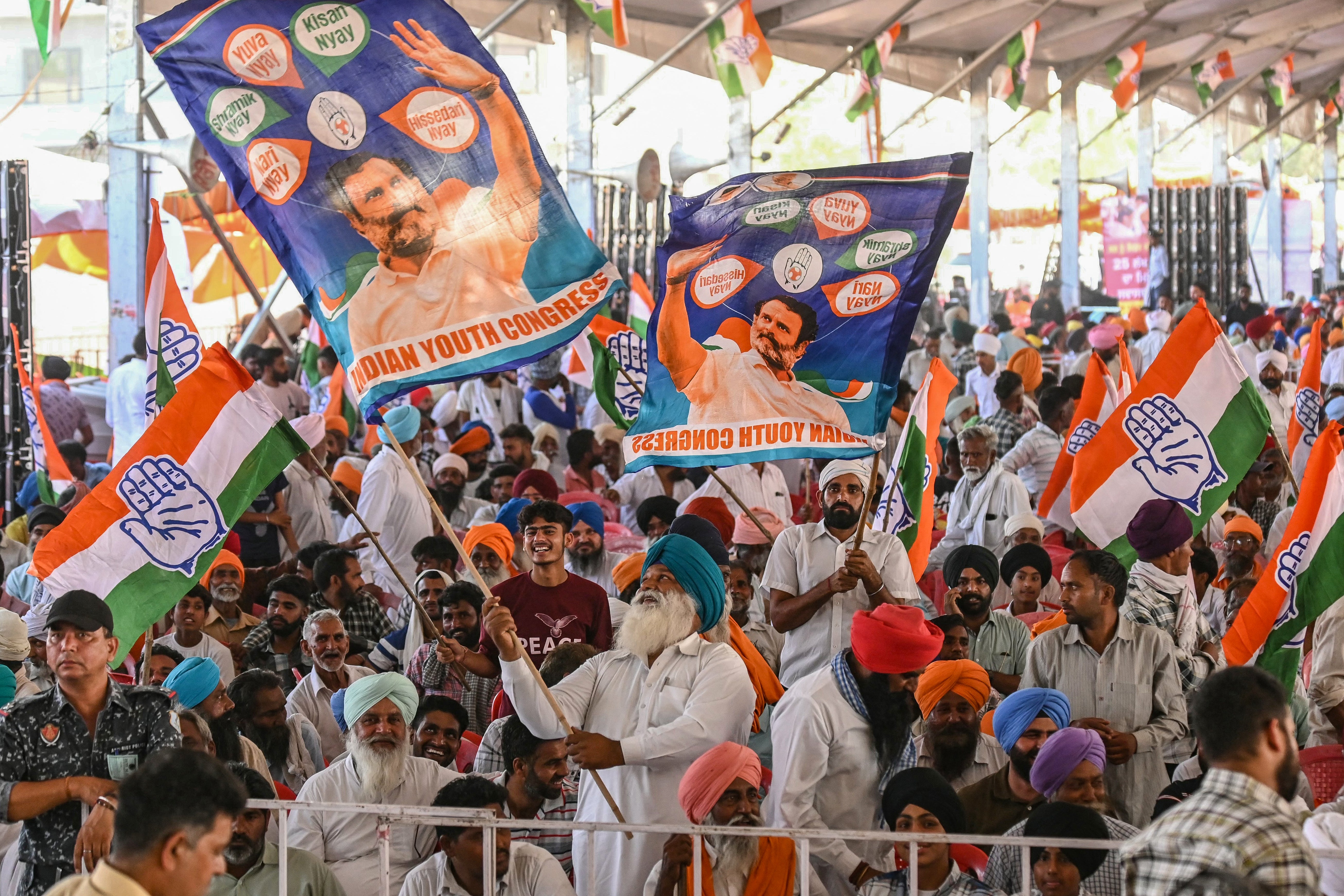 Supporters wave flags with images of Indian National Congress (INC) party leader Rahul Gandhi during an election rally in Amritsar on 25 May