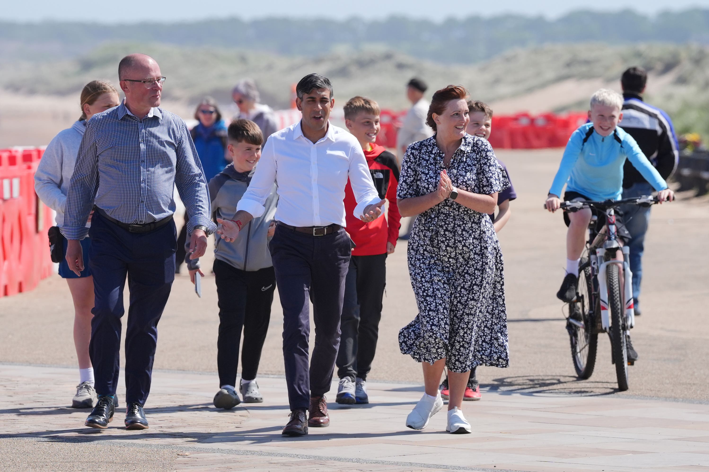 Prime Minister Rishi Sunak walks with husband and wife Ian and Maureen Levy, Conservative parliamentary candidates for Cramlington and Killingworth, and Blyth and Ashington, respectivley, at Blyth Beach in the North East of England while on the General Election campaign trail (PA)