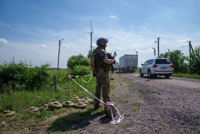 <p>FILE: A Ukrainian soldier guards his position while trucks with killed Russian soldiers driving to Russian territory, during repatriation in Sumy region, Ukraine, Friday, 31 May 2024</p>