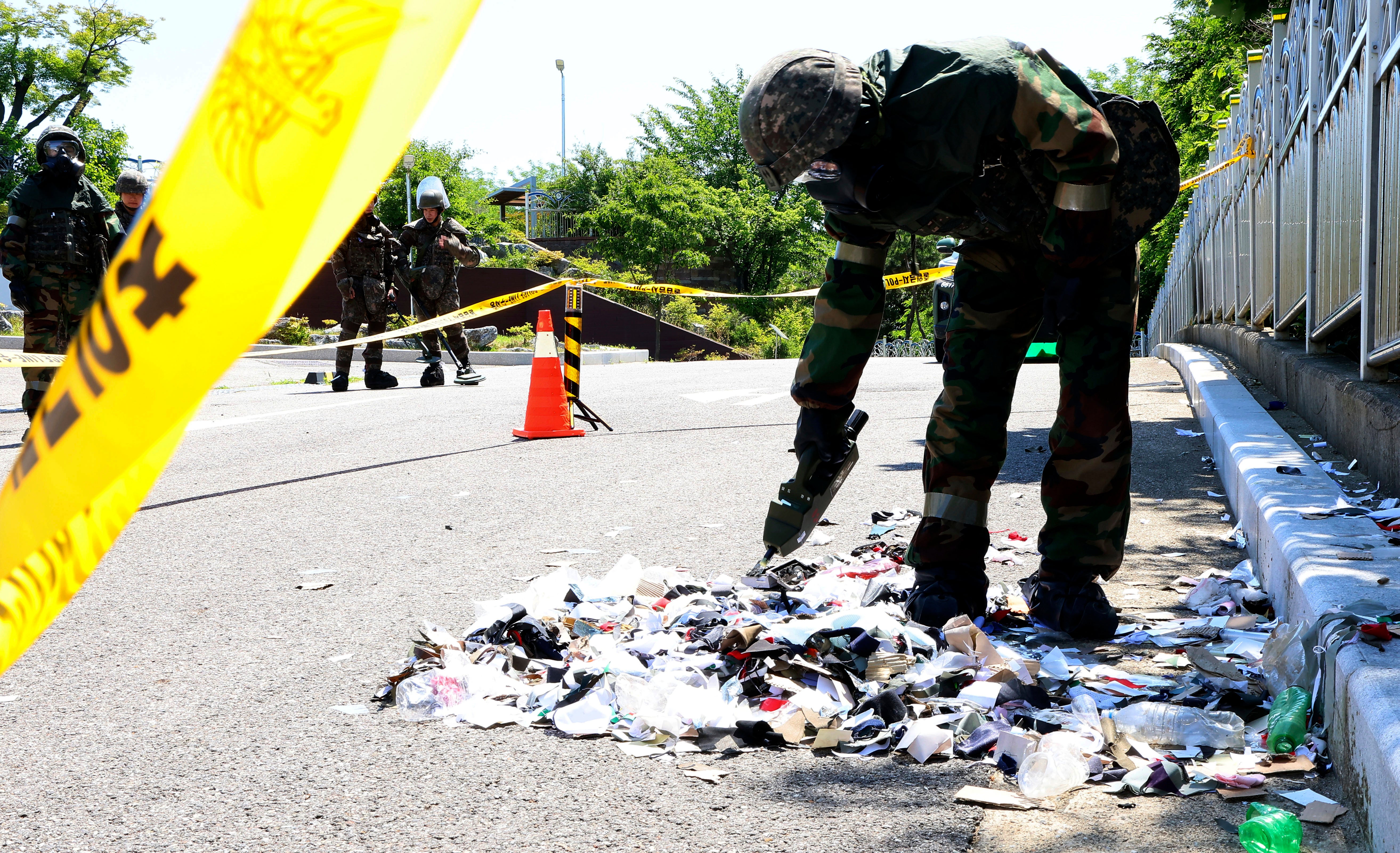 <p>South Korean soldier wearing protective gears checks the trash from a balloon presumably sent by North Korea, in Incheon, South Korea, on Sunday</p>