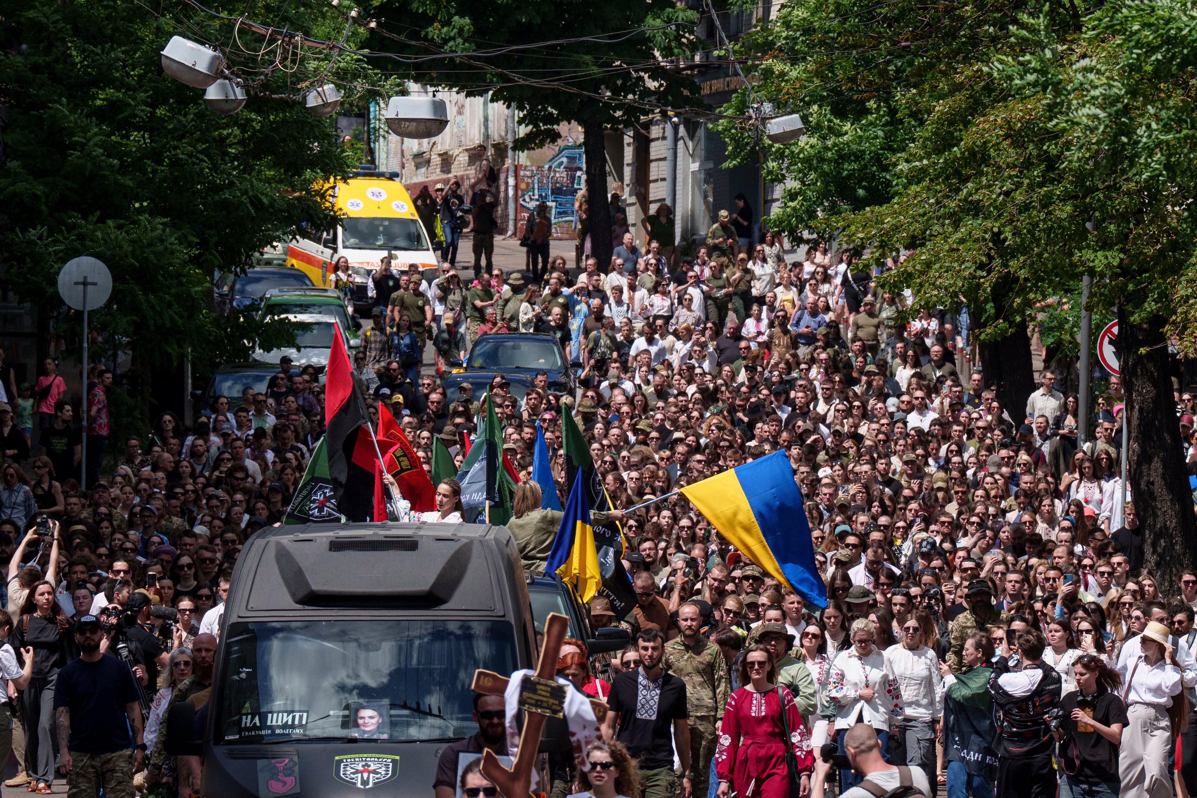 People walk along Mykhailivska Street during a memorial service for Ukrainian journalist and volunteer combat medic Iryna Tsybukh at St. Michael's Golden-Domed Monastery in Kyiv,