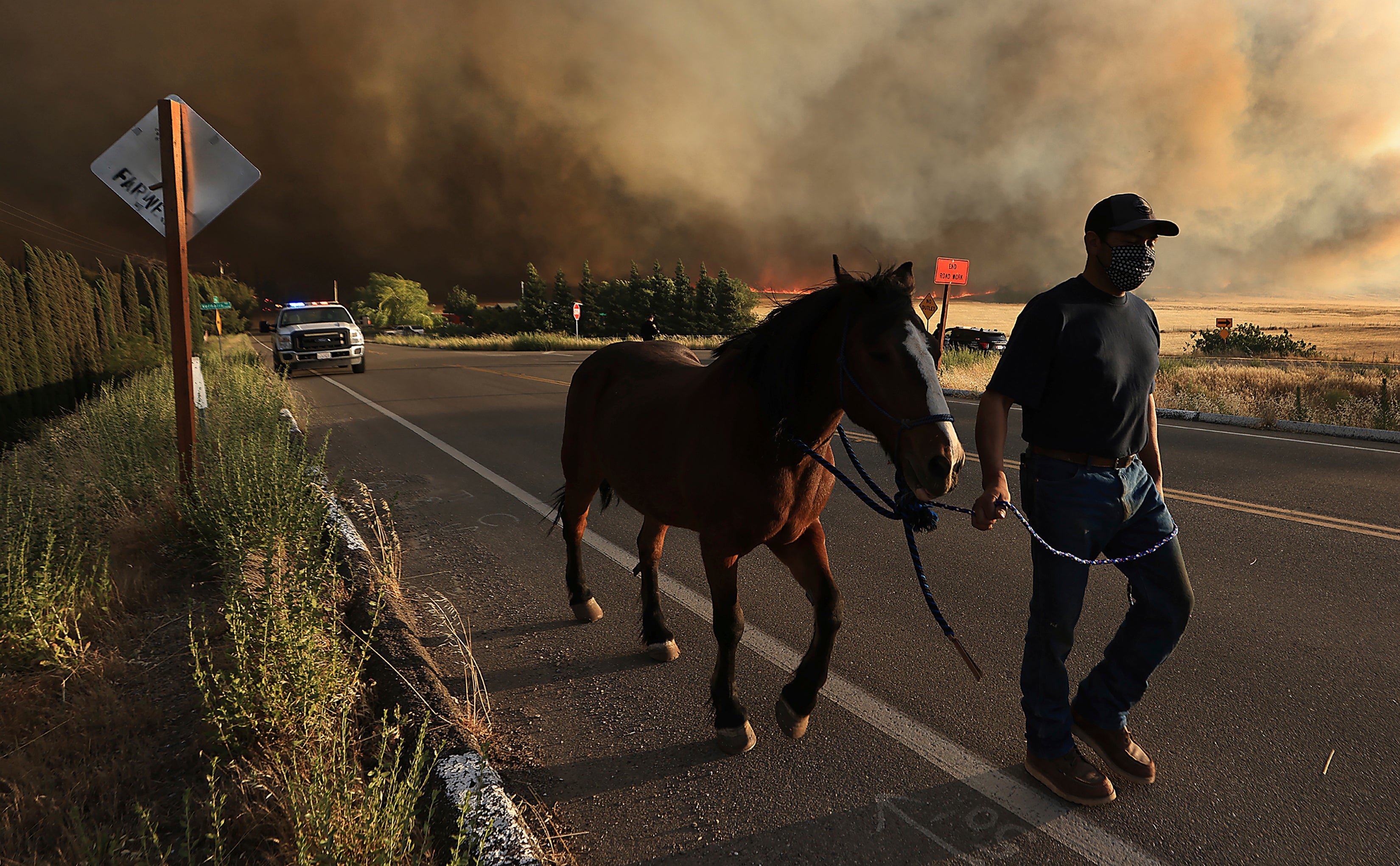 Ein Anwohner der Vernalis Road evakuiert sein Pferd, als das Korallenfeuer am Samstag, den 1. Juni 2024 auf Ranches westlich von Tracy, Kalifornien, niedergeht.