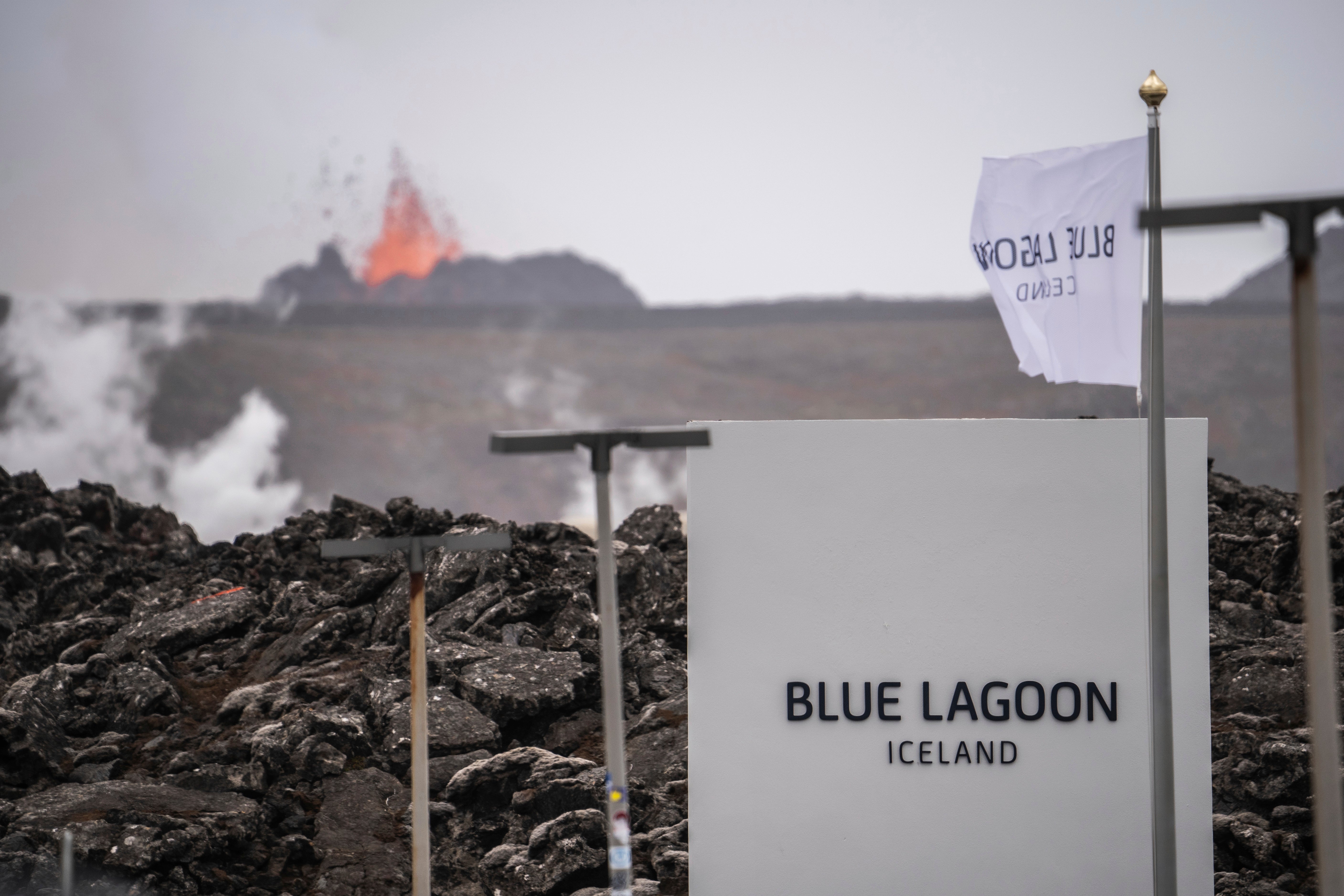 A entrada da Lagoa Azul enquanto o vulcão entra em erupção ao fundo em Grindavik, Islândia, domingo, 2 de junho de 2024