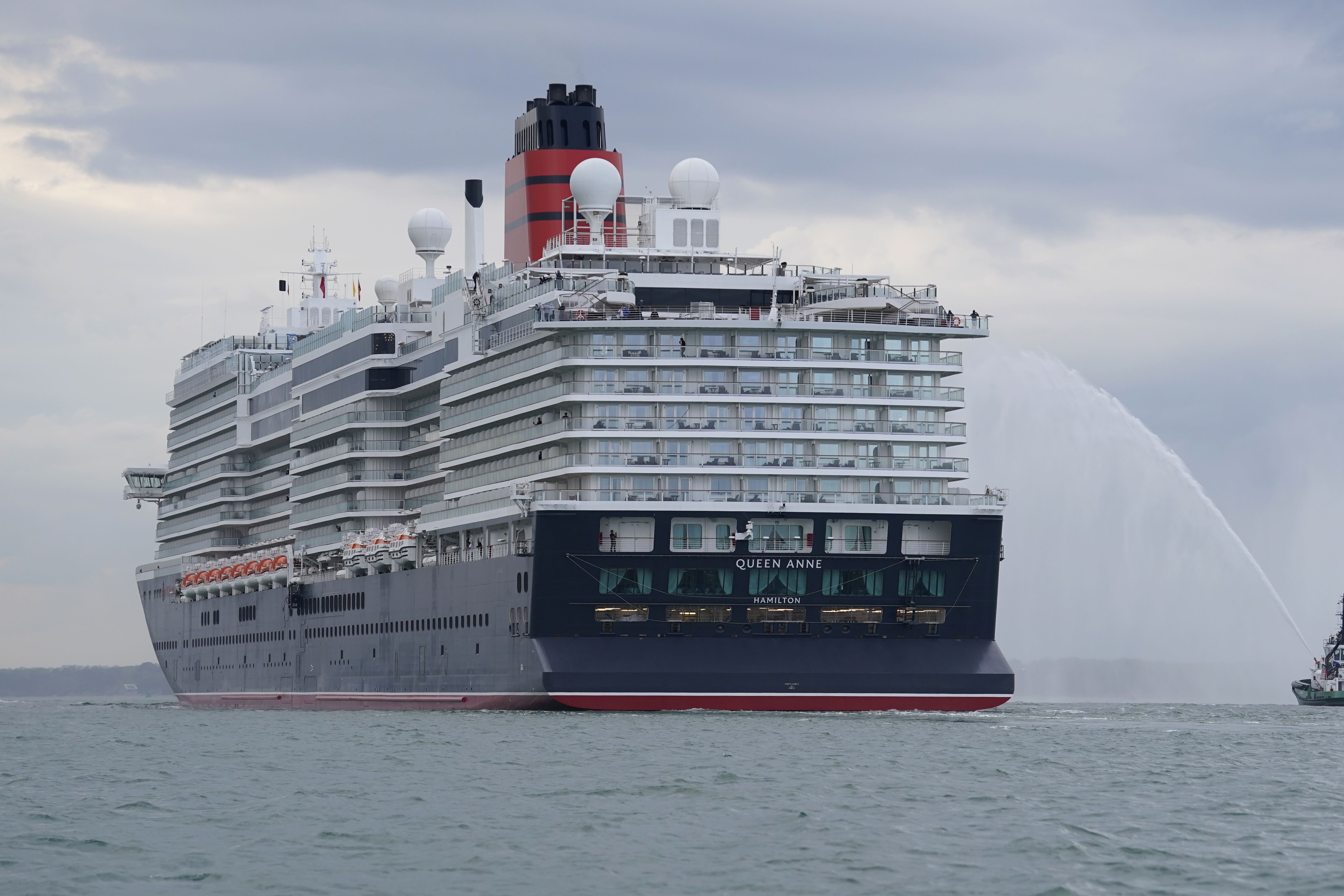 A tug boat sprays water at Cunard’s newest cruise ship Queen Anne (Andrew Matthews/PA)