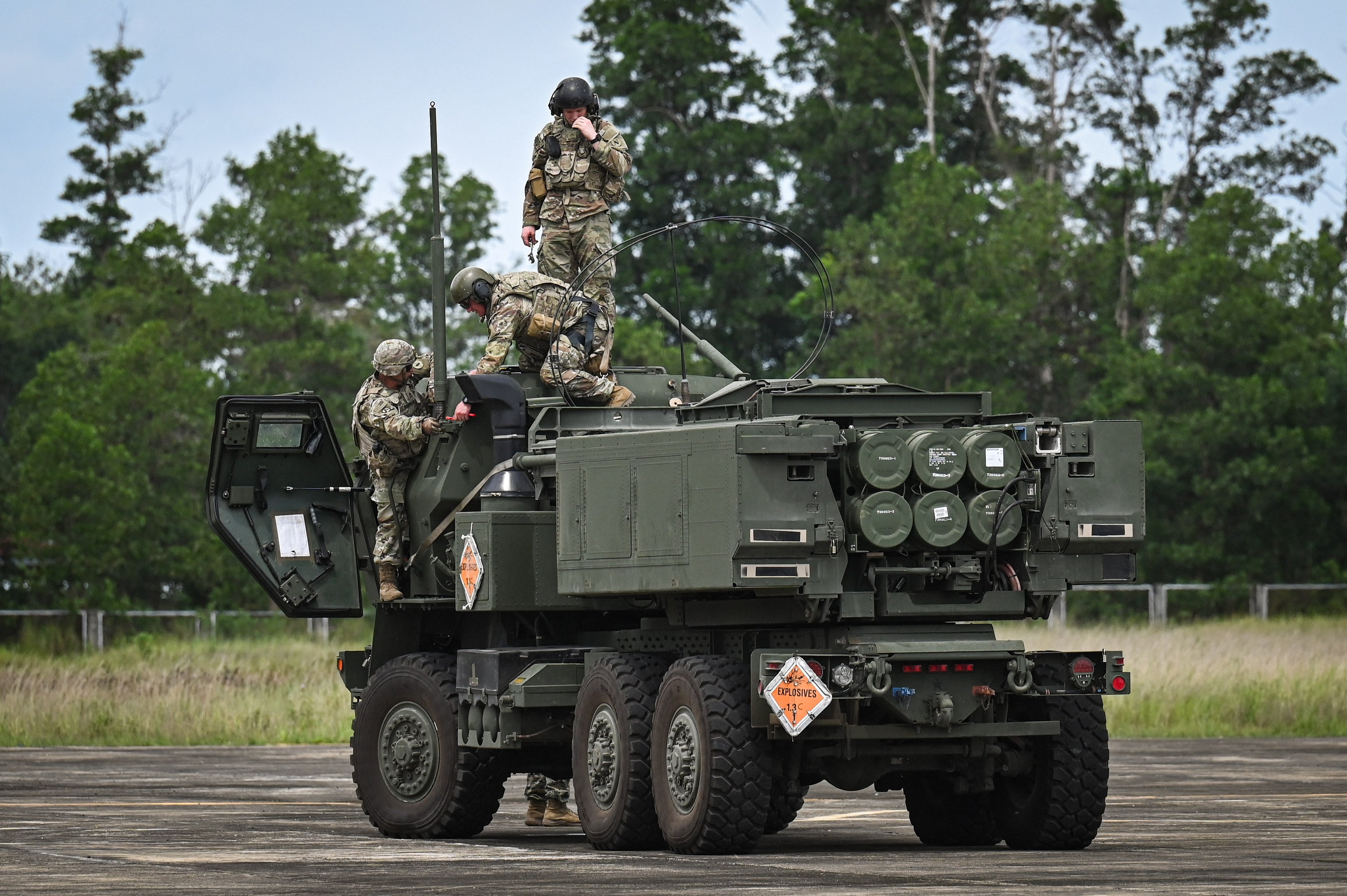 Soldiers put up the antenna of the HIMARS during an airfield seizure exercise