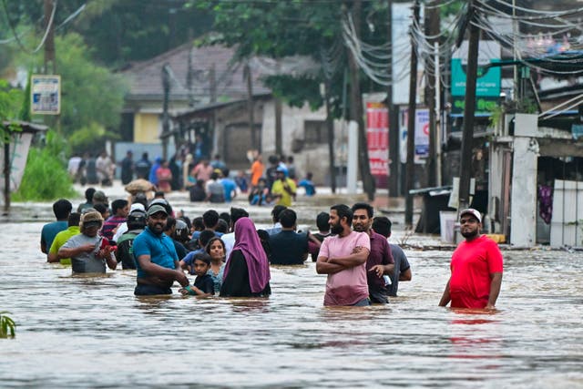 <p>Sri Lankans wade through a flooded street in Malwana on the outskirts of Colombo </p>