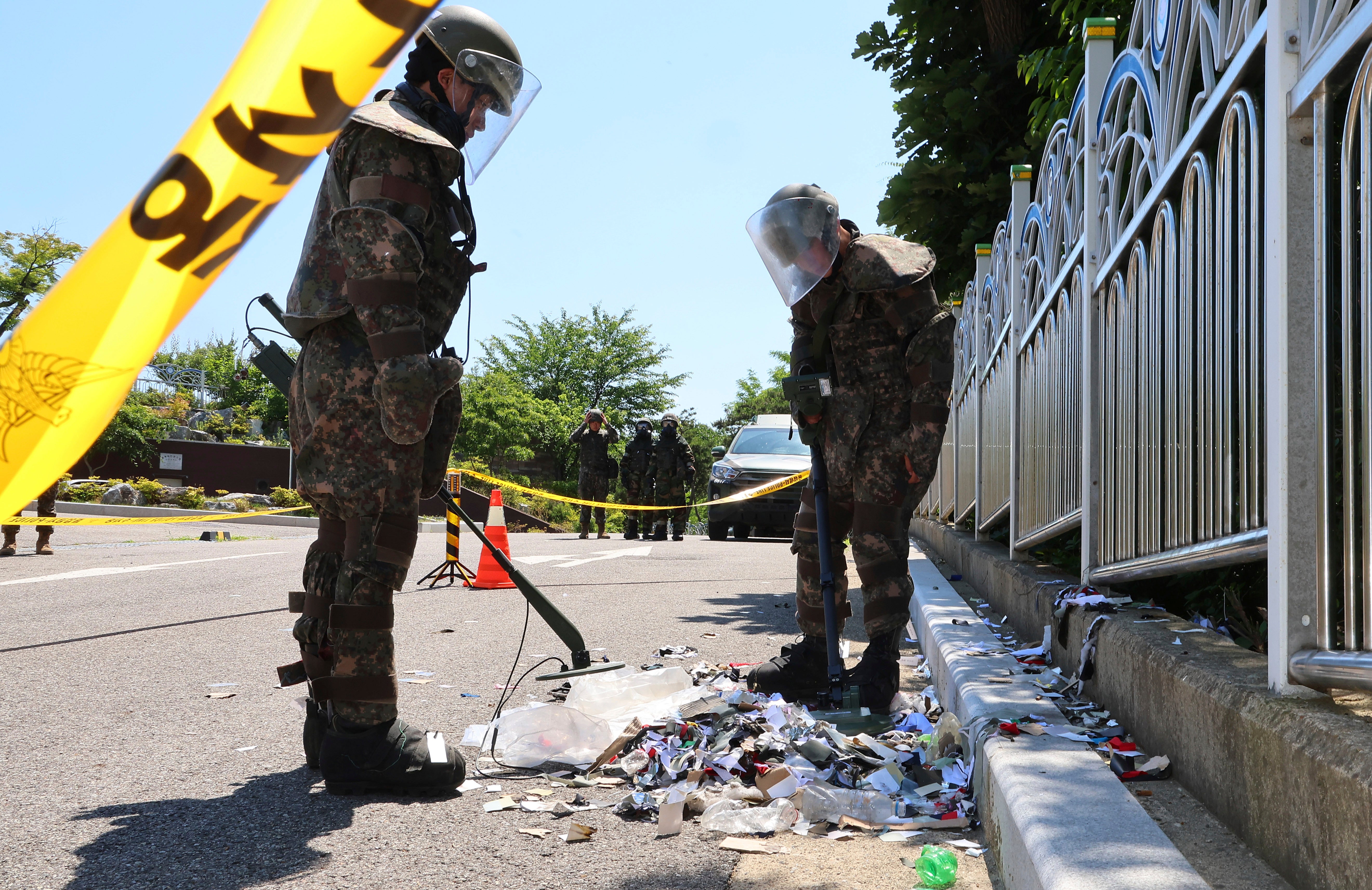 South Korean soldiers wearing protective gear check trash from a balloon presumably sent by North Korea, in Incheon