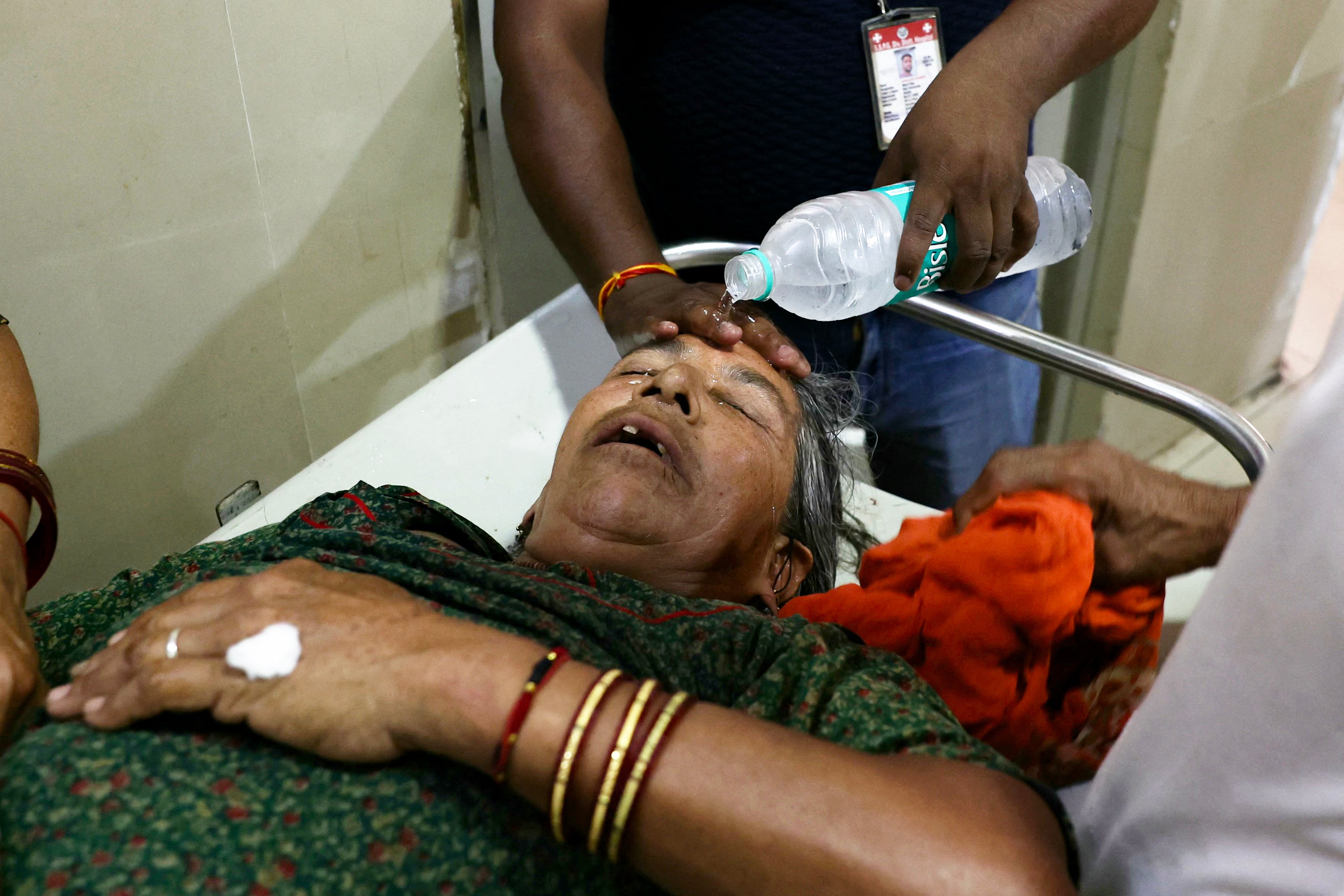 A hospital employee pours water on the face of a heat stroke patient at a government hospital in Varanasi, where the heat wave was severe.