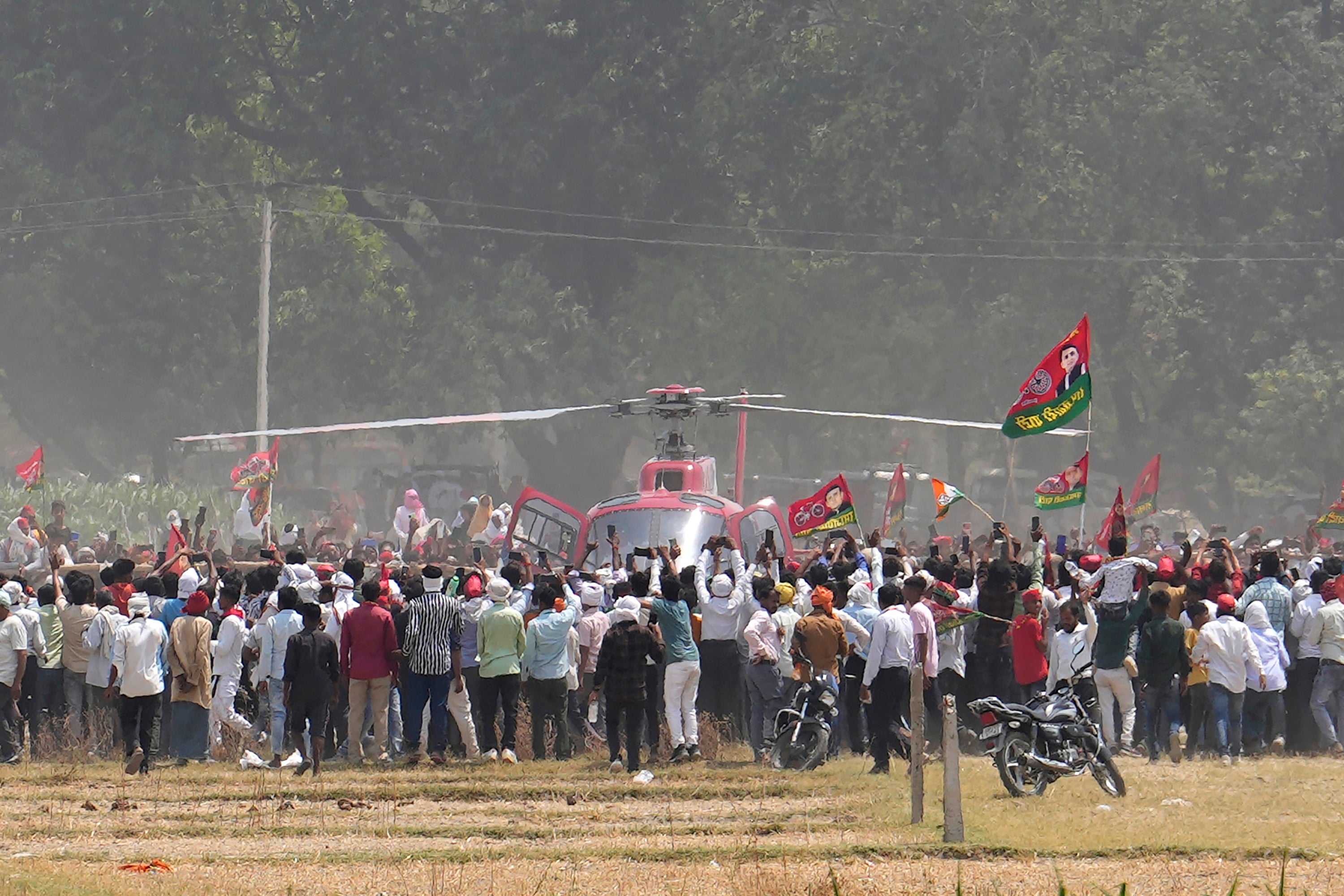 Samajwadi Party’s supporters rush towards a helicopter bringing party leader Akhilesh Yadav to an election rally in Prayagraj, Uttar Pradesh, on 19 May 2024