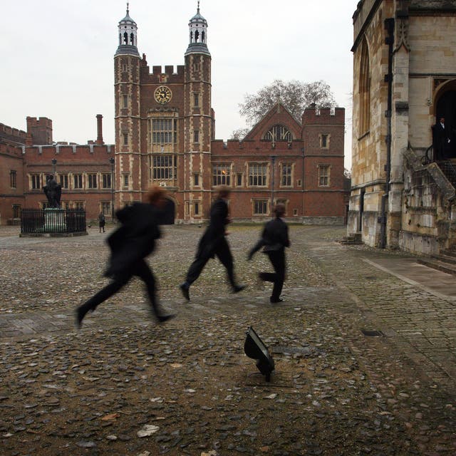 <p>Pupils run across the historic cobbled yard at Eton College </p>