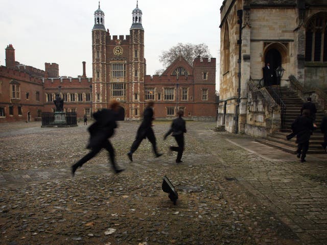 <p>Pupils run across the historic cobbled yard at Eton College </p>