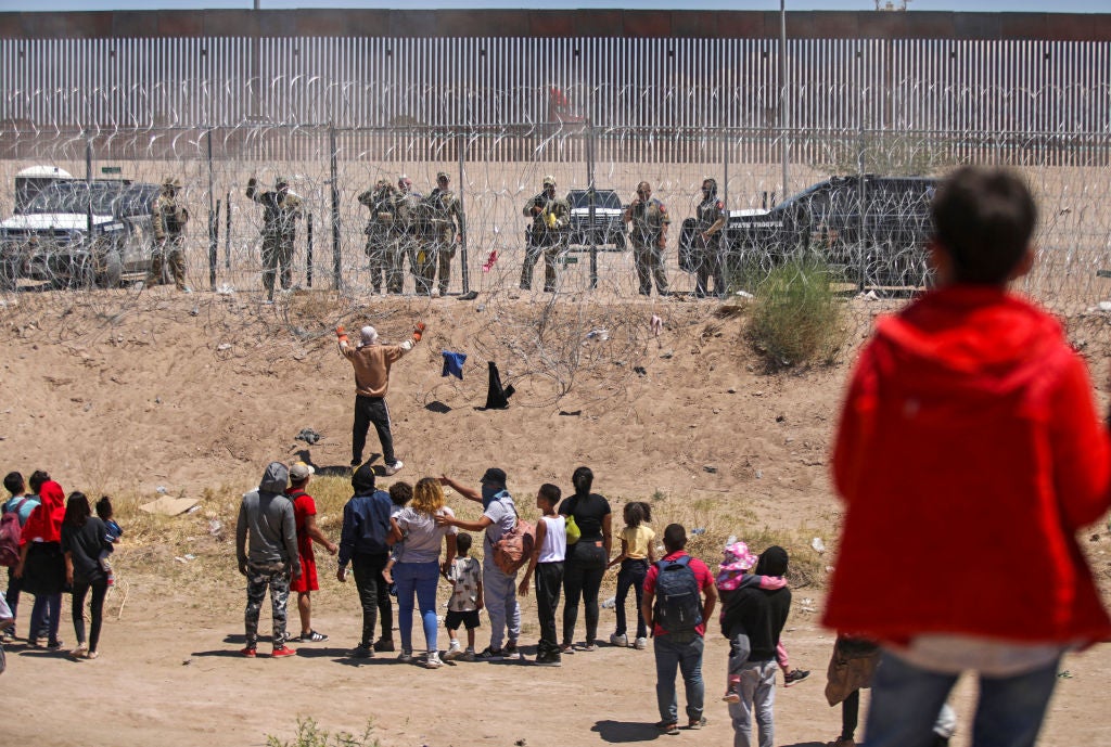 Migrants on the Mexican side of the US-Mexico border engage in a confrontation with Texas National Guard troops