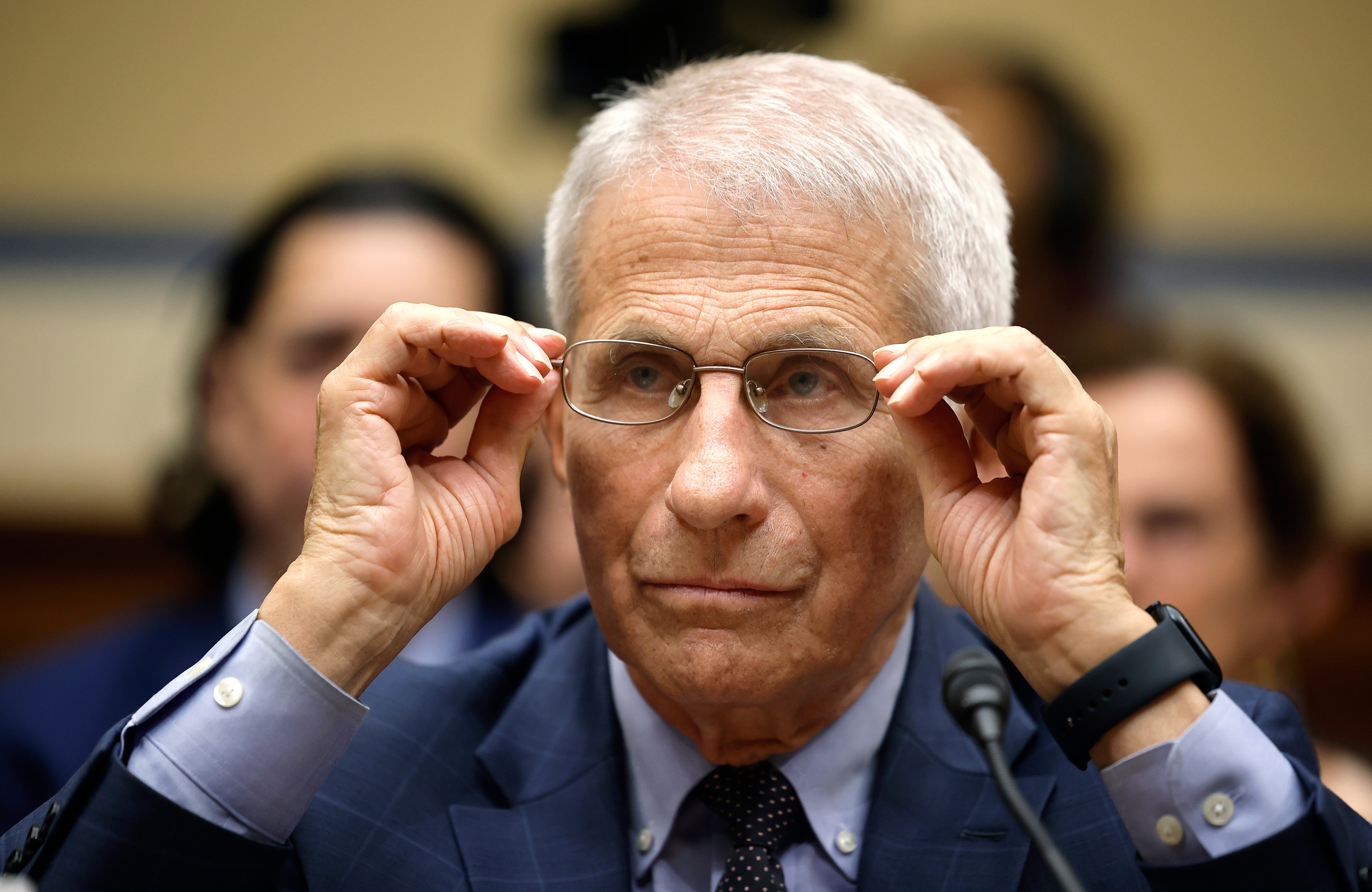 Dr Fauci adjusts his glasses as he testifies