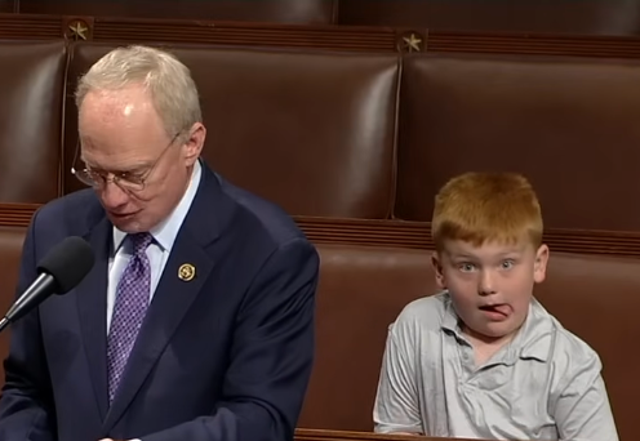 <p>Representative John Rose (R-Tenn.) gives a speech on June 3, 2024, at the House of Representatives, while his son Guy makes funny faces behind him</p>