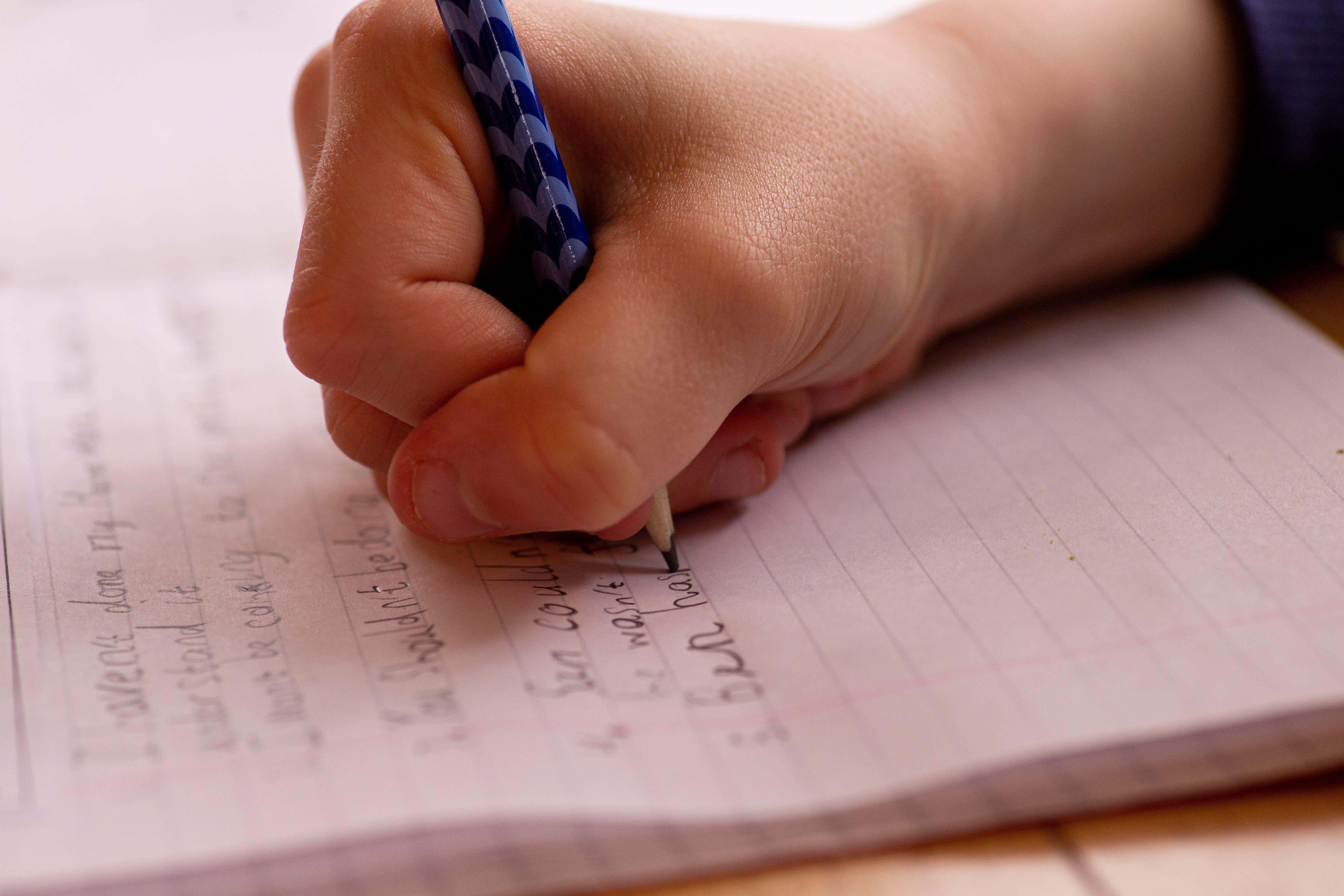 A child writing lines (Alamy/PA)