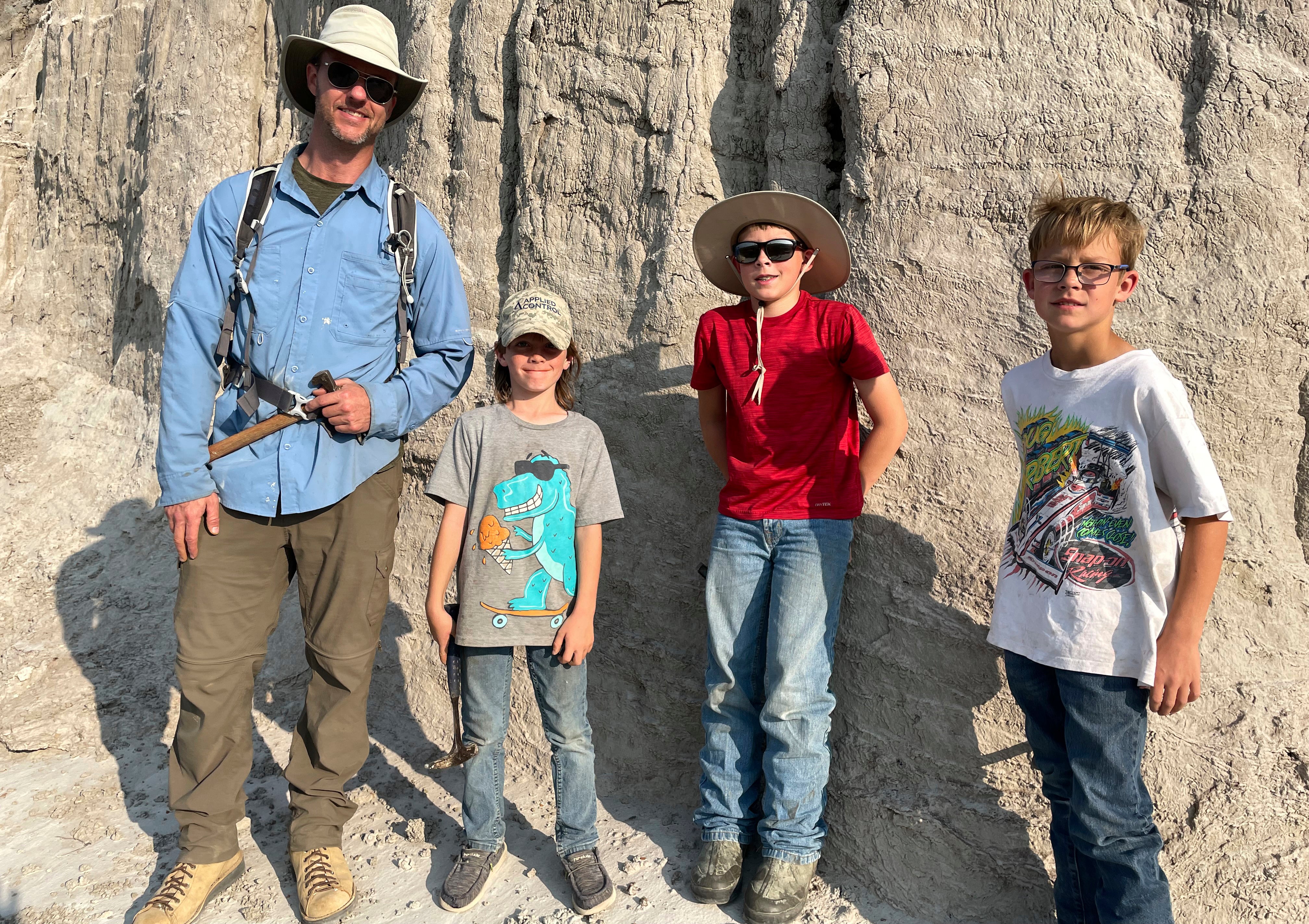 Vertebrate paleontologist Tyler Lyson, left, poses with young fossil finders Liam Fisher, Jessin Fisher and Kaiden Madsen