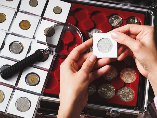 <p>A box with collectible coins in cells and a hand holding a coin. According to a May YouGov poll of nearly 3,000 American adults, over 80 percent reported they would stop to pick up coins on the street, with the habit being common among older adults. </p>