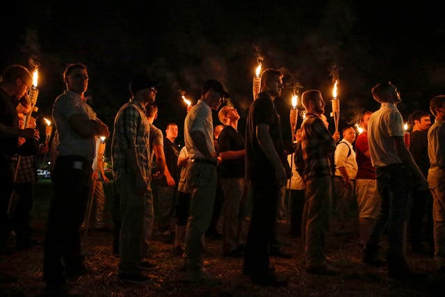 <p>Multiple white nationalist groups march with torches through the University of Virginia campus on August 11, 2017</p>
