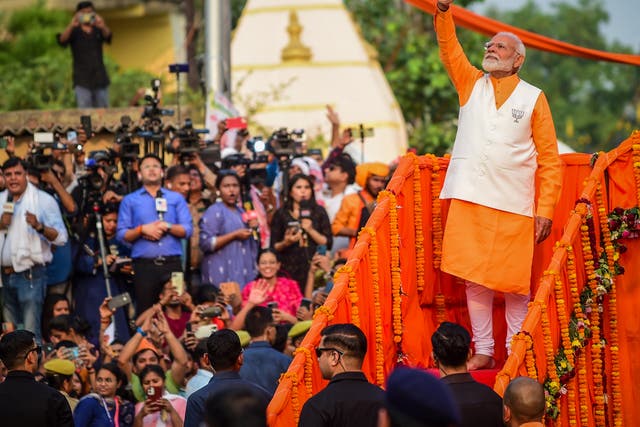 <p>Narendra Modi greets supporters during a campaign roadshow in the northern city of Varanasi on 13 May 2024</p>
