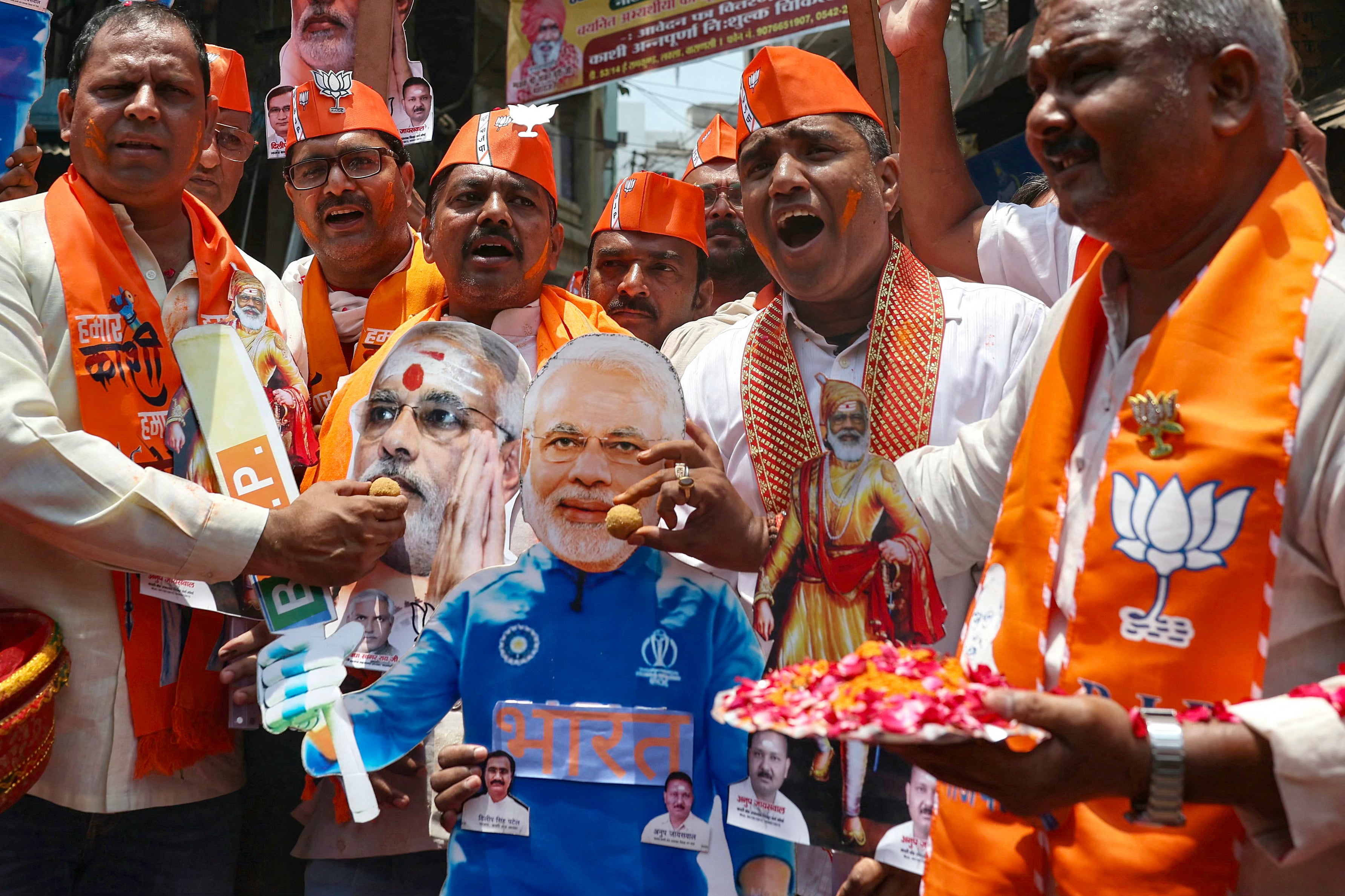 Supporters of Narendra Modi, India’s Prime Minister and leader of Bharatiya Janata Party (BJP) feed sweets to his cut-outs as they celebrate vote counting results for India’s general election in Varanasi on 4 June 2024