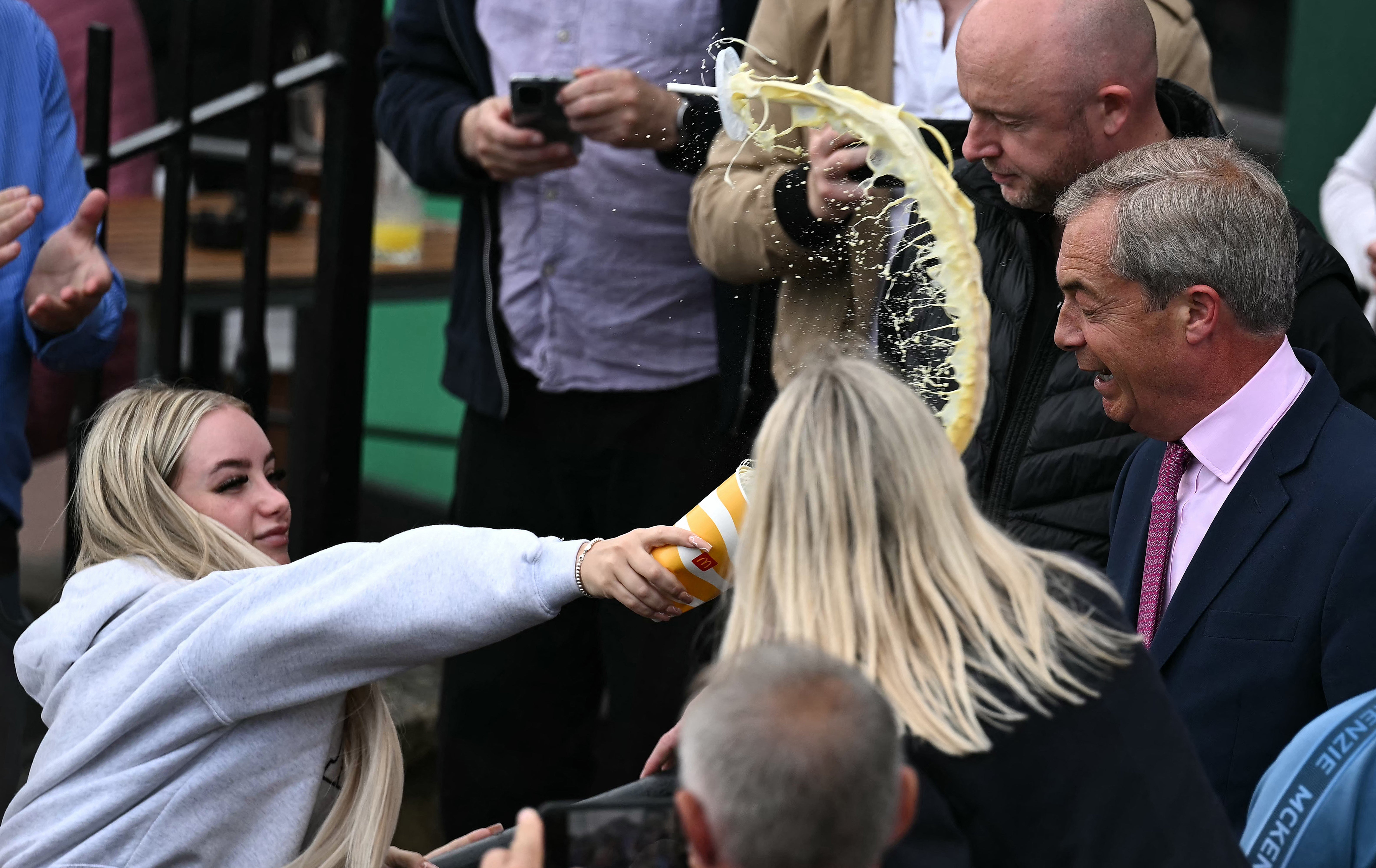 Young woman throws milkshake at Farage