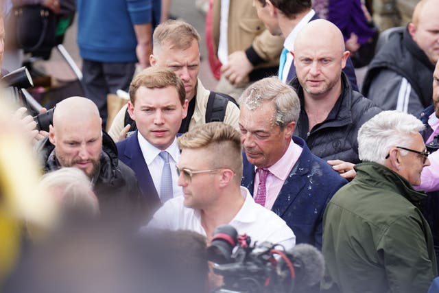 Leader of Reform UK Nigel Farage has a drink thrown over him as he leaves the Moon and Starfish pub after launching his General Election campaign in Clacton-on-Sea, Essex (James Manning/PA)