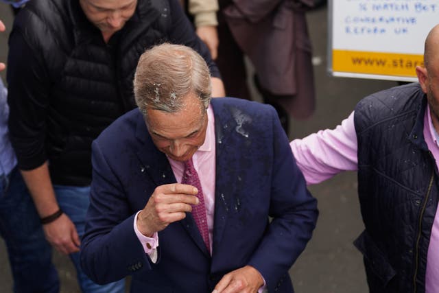 Leader of Reform UK Nigel Farage after a drink was thrown over him as he leaves the Moon and Starfish pub in Clacton (James Manning/PA)