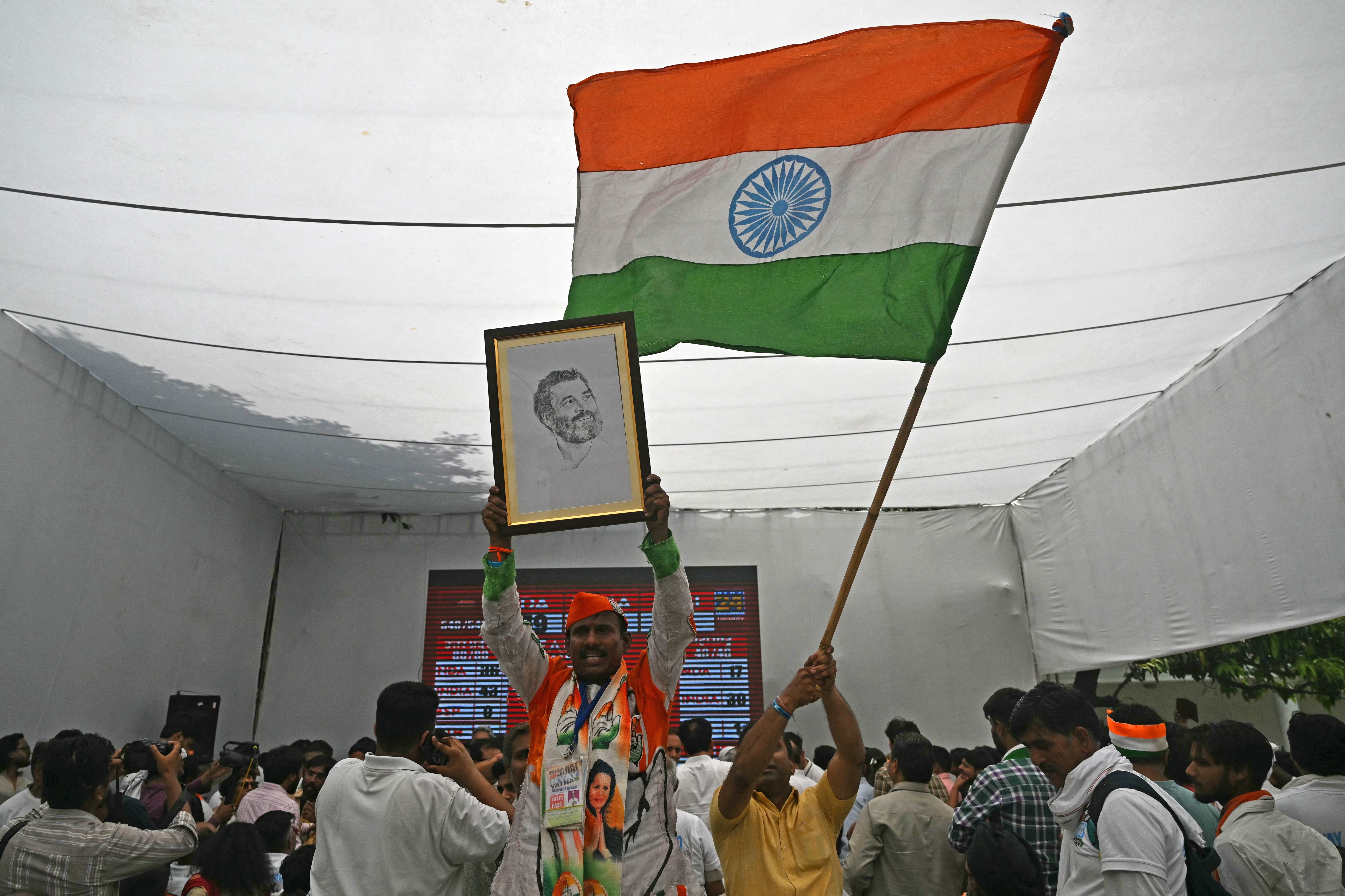 Supporters of the Congress party hold a portrait of Rahul Gandhi and wave India’s national flag after the votes were counted in India’s national election, in Delhi on 4 June 2024
