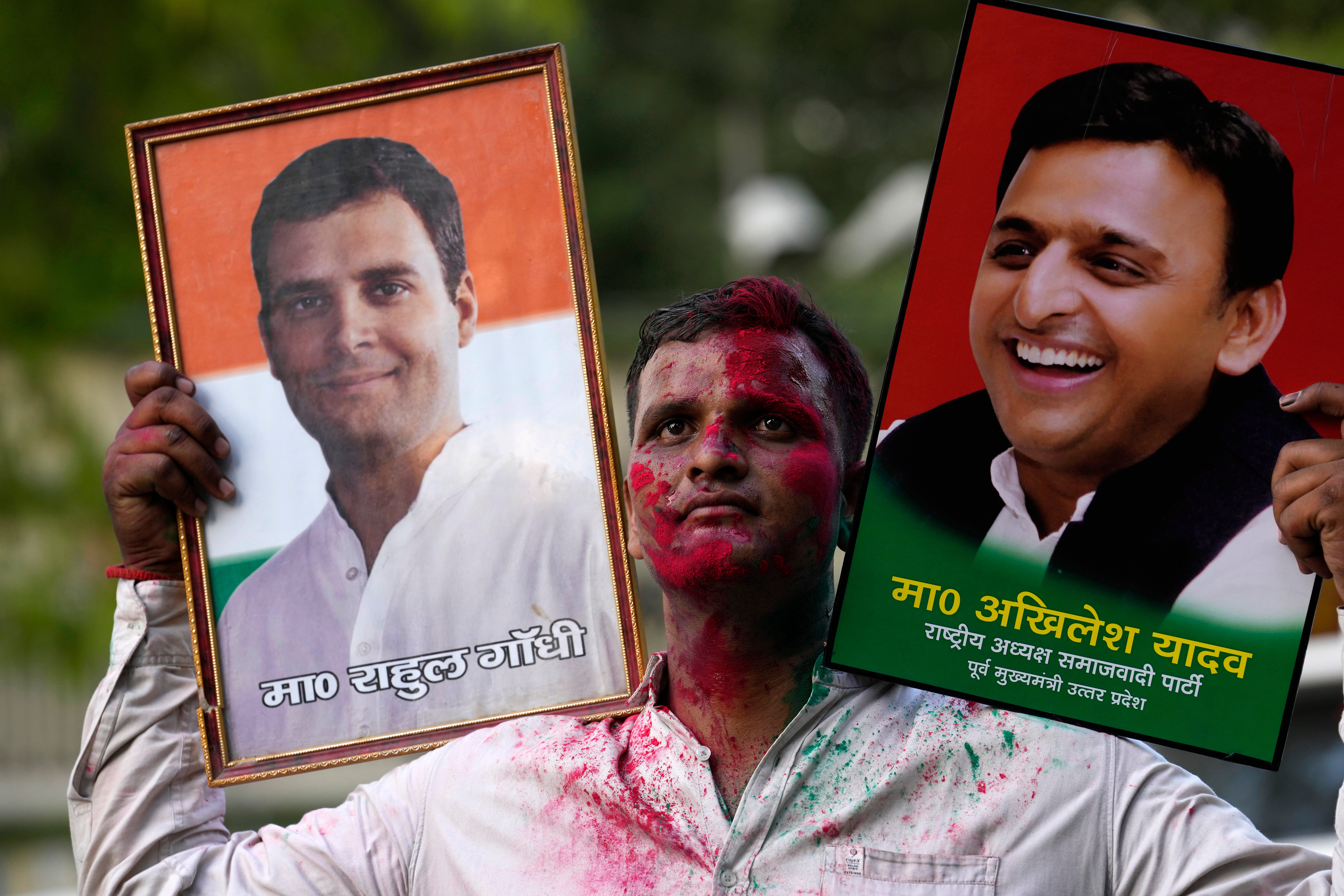 A Samajwadi Party supporter carries portraits of his party leader Akhilesh Yadav and Congress party’s Rahul Gandhi after the counting of votes in India’s national election, in Lucknow, Uttar Pradesh, on 4 June 2024