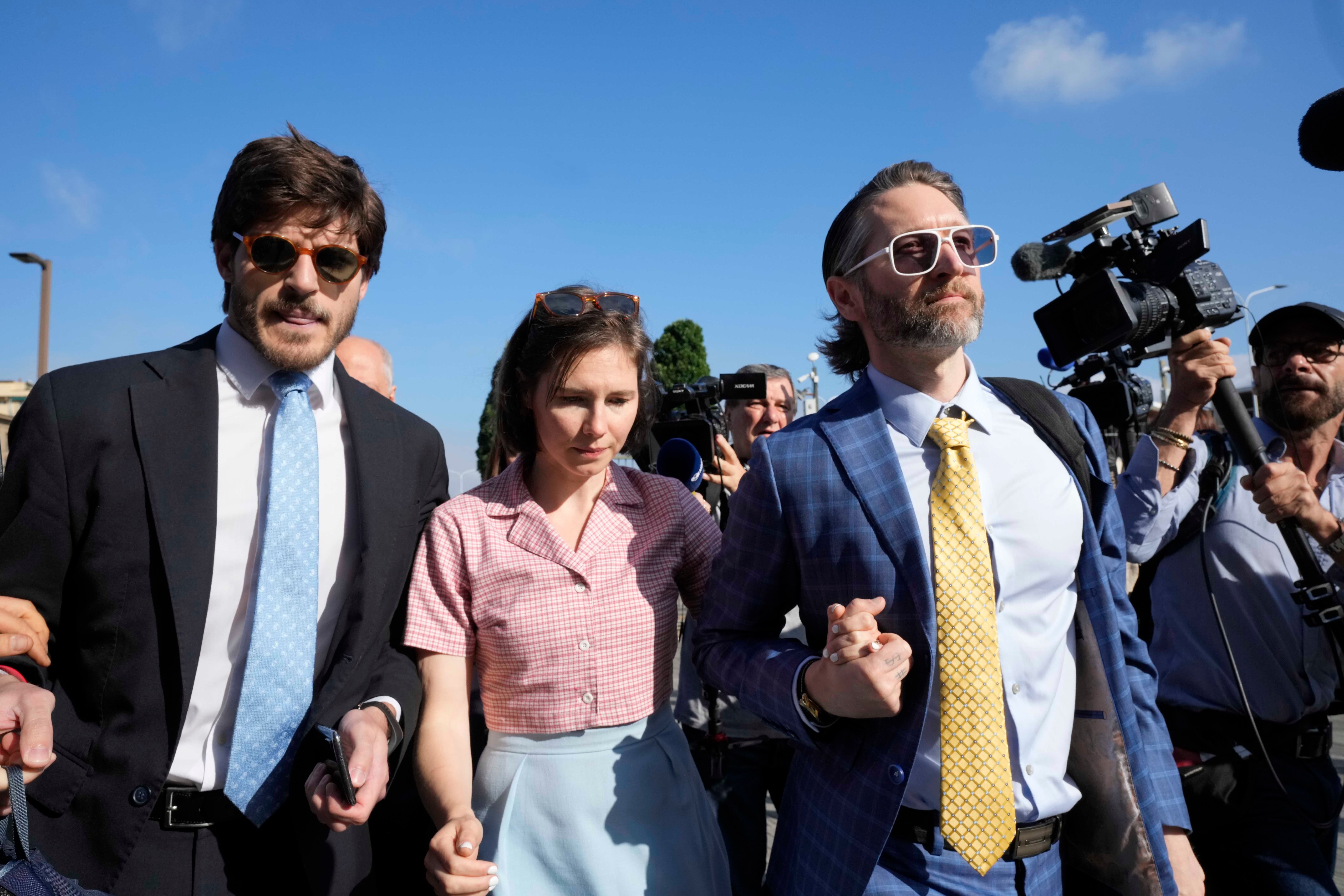 Knox arrives flanked by her husband Christopher Robinson, right, and her lawyer Luca Luparia Donati