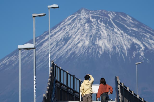 <p>People look towards Mount Fuji </p>