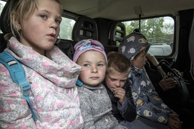 <p>Four of Valentyna’s children - Tetiana, 10, Angelina, 6, Iaroslav, 8, and Sasha, 9 - are pictured in the back of a minibus as they drive towards Kharkiv from the hometown of Zakharivka</p>
