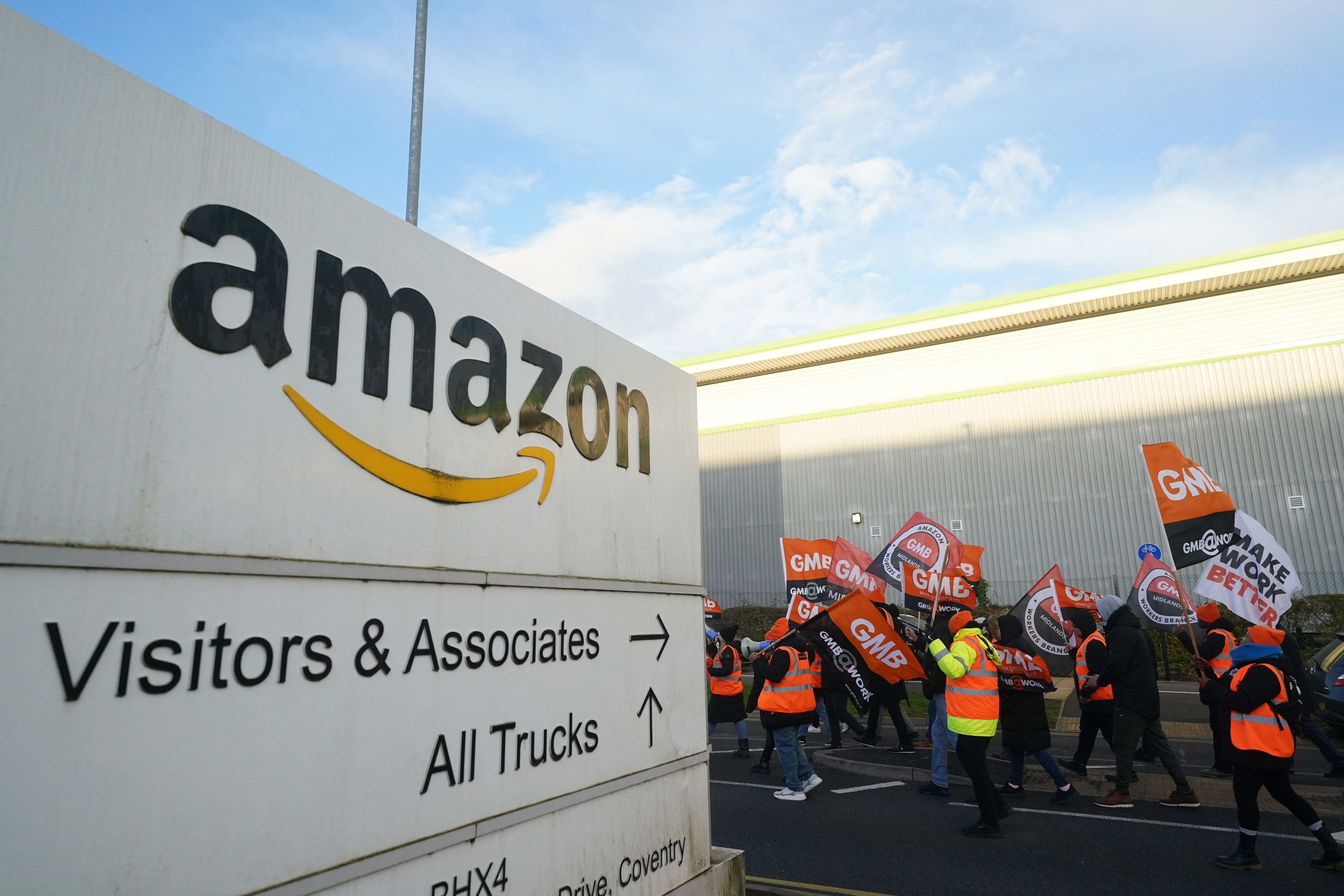 Members of the GMB union on the picket line stand in front of a freight lorry outside the Amazon fulfilment centre in Coventry (Jacob King/PA)