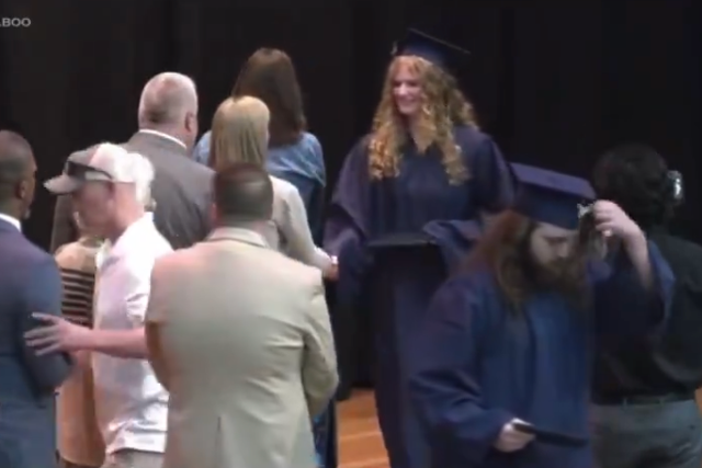 <p>An unnamed father of a graduate pictured shoving Superintendent Rainey Briggs (far left) off the stage. In 2018, the same high school made national news after a photo emerged of dozens of students performing the Nazi salute</p>