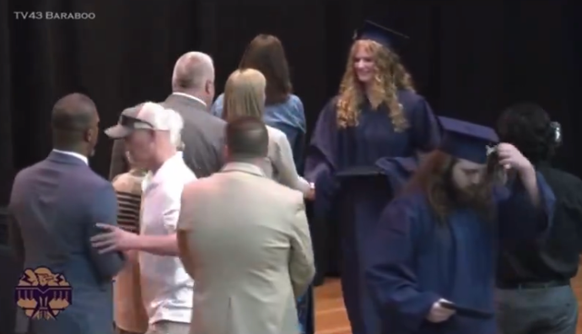 <p>An unnamed father of a graduate pictured shoving Superintendent Rainey Briggs (far left) off the stage. In 2018, the same high school made national news after a photo emerged of several students performing the Nazi salute</p>