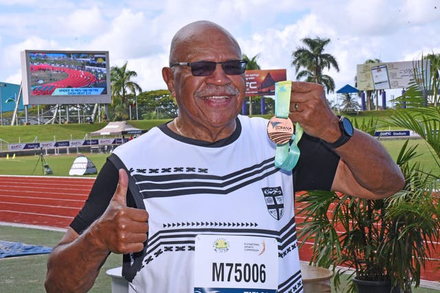 <p>Fiji prime minister Sitiveni Rabuka hold his bronze medal at the Oceania athletics championships</p>