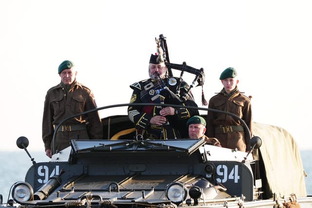 A military piper comes into shore on a DUKW amphibious vehicle ahead of playing a dawn lament on Gold Beach in Arromanches in Normandy, France, to commemorate the 80th anniversary of the D-Day landings (Aaron Chown/AP)