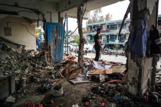 <p>A Palestinian boy stands in the UN school destroyed by an Israeli strike in Nuseirat</p>